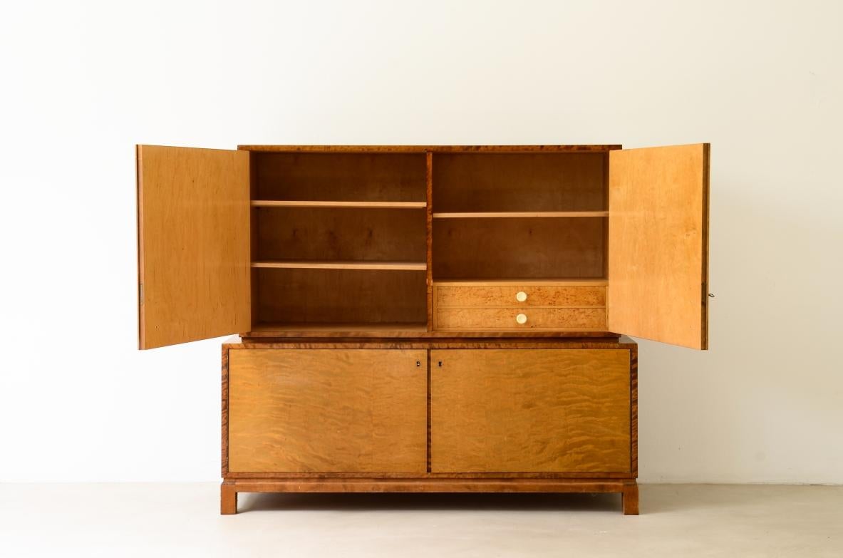 COD-2686
Storage unit in the style of Axel Einar Hjort, in flamed maple with Art Deco inlays on the front. Inside, shelves and drawers with galalith knobs.

Sweden  approx. 1930

140 x 45 h 132 cm