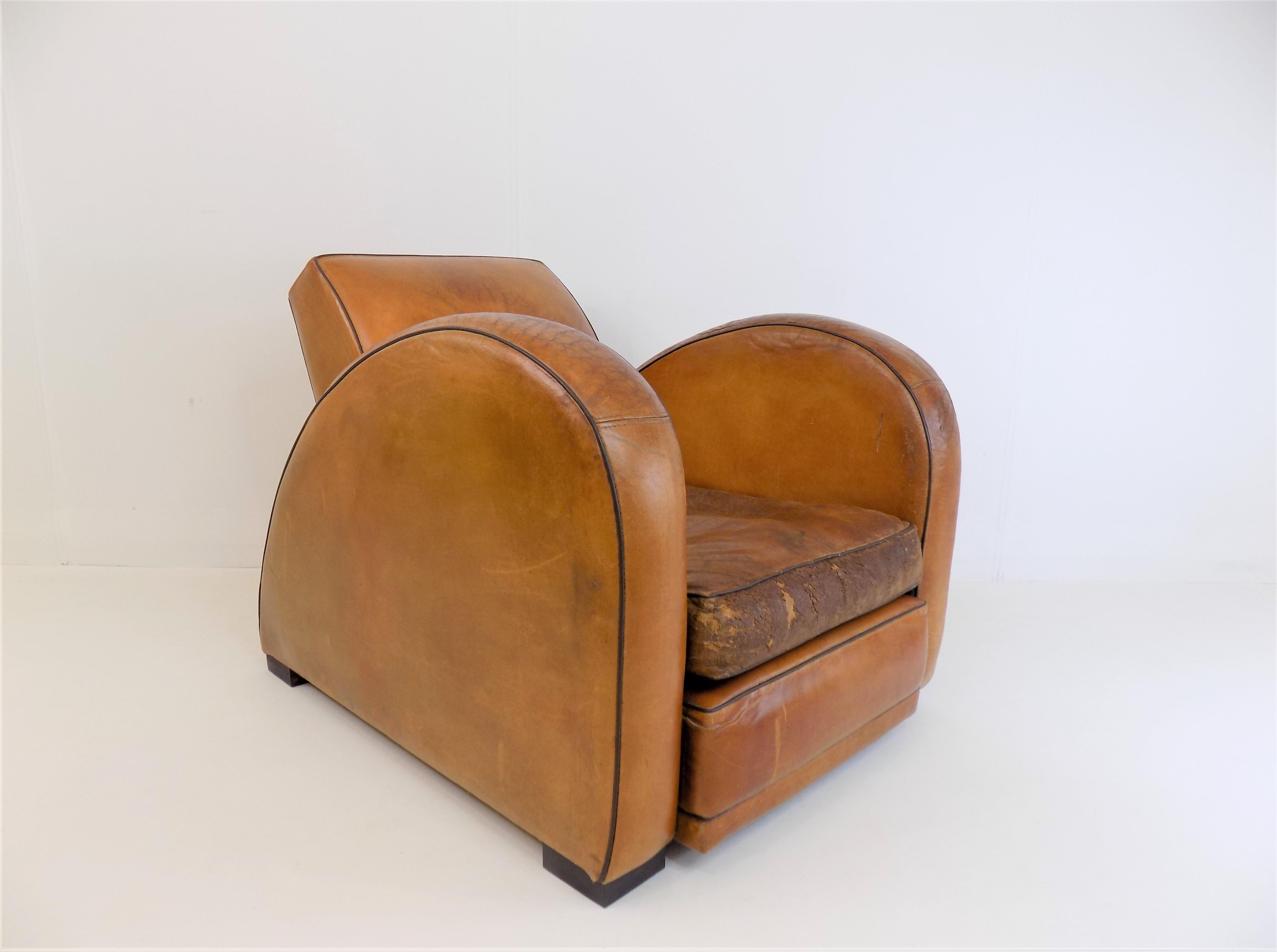 More sculpture than armchair, this armchair comes in a cognac-colored leather and immediately dominates any room. The leather has hard earned its patina over the years and has been reinforced from the inside in the front area of the seat cushion to