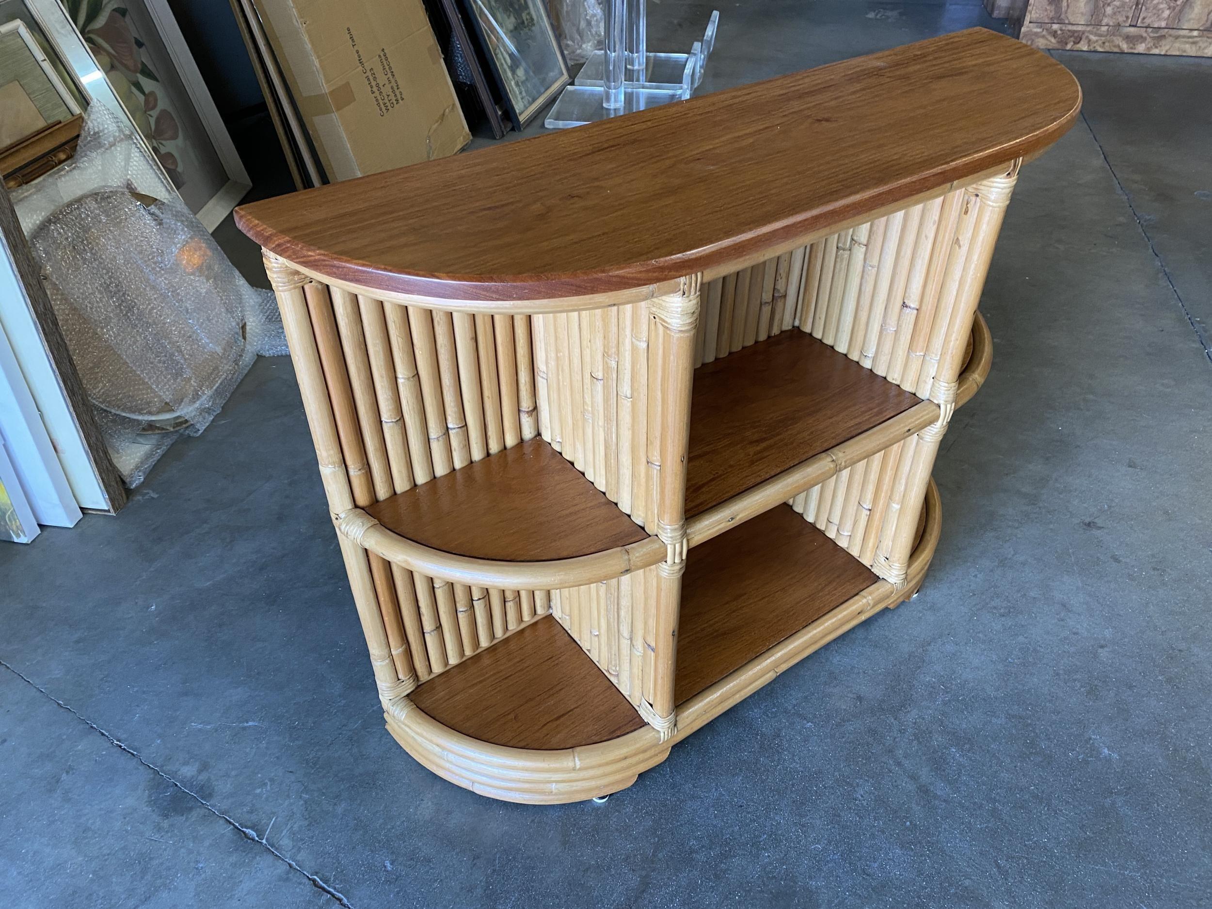 Circa 1940 6-tier rattan shelf/console table with mahogany shelving and tabletop. This small shelf doubles as a shelf and a console table, perfect for use as a focal point in a living room, lobby, or hallway.
1940, USA
We only purchase and sell only