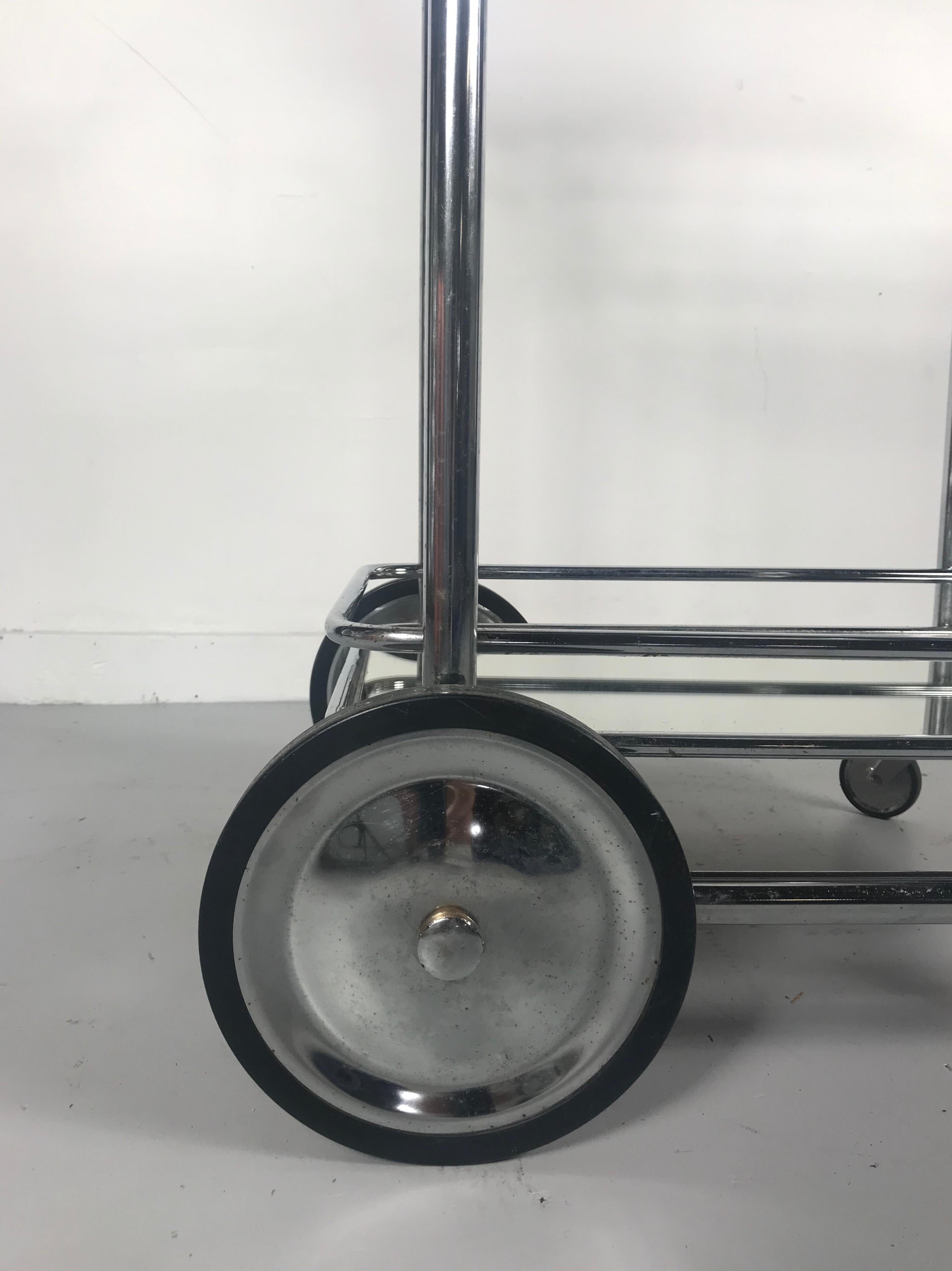 Art Deco streamline tubular chrome and glass rolling bar cart or trolley, wonderful scale and proportion, Bauhaus inspired, retains original mirror and glass shelves. Fit seamlessly into any modernist, contemporary, antique eclectic environment.