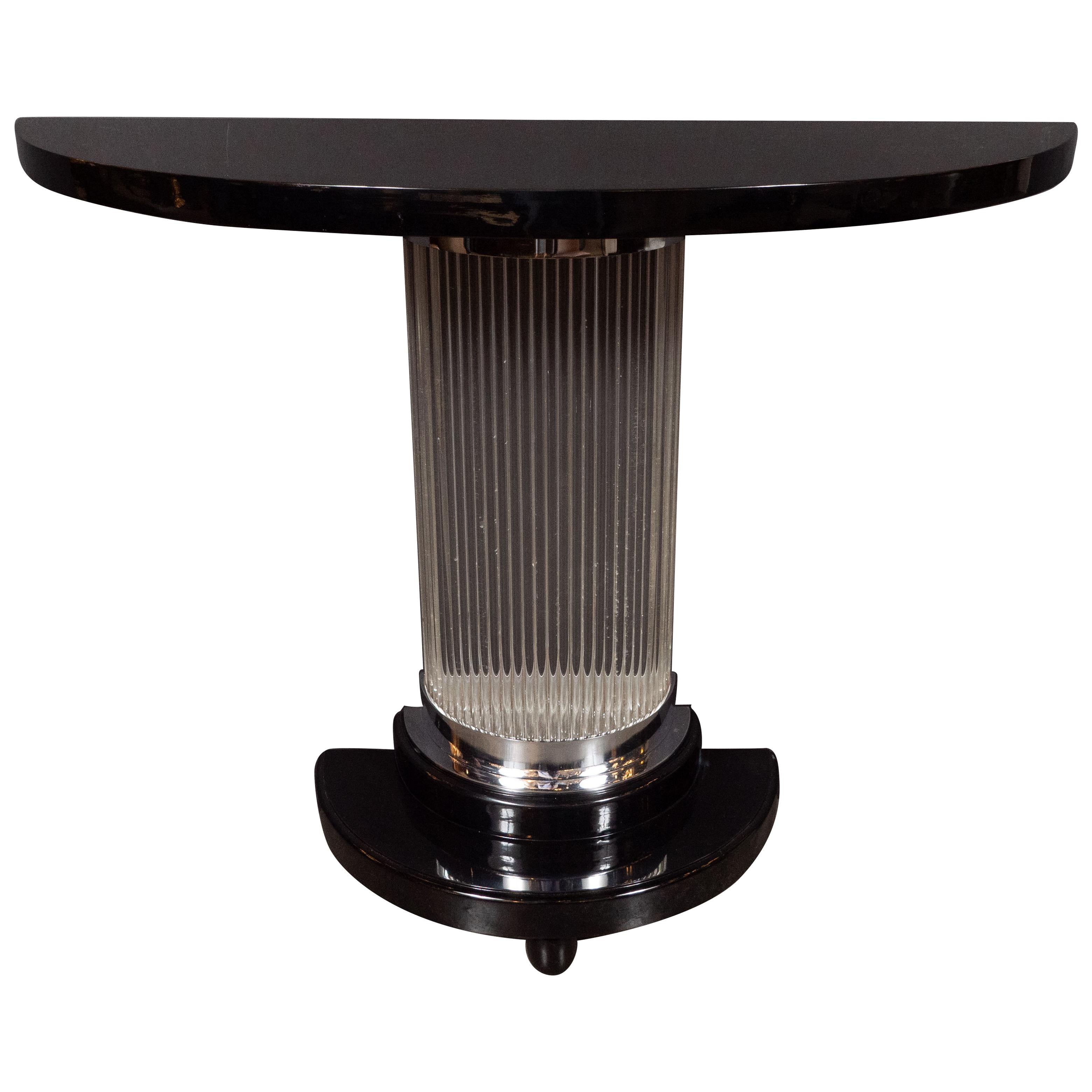 This stunning Art Deco Machine Age console table was realized in the United States, circa 1935. It features a streamlined demilune form black lacquer top with a stepped skyscraper style base of the same shape with chrome detailing and rounded
