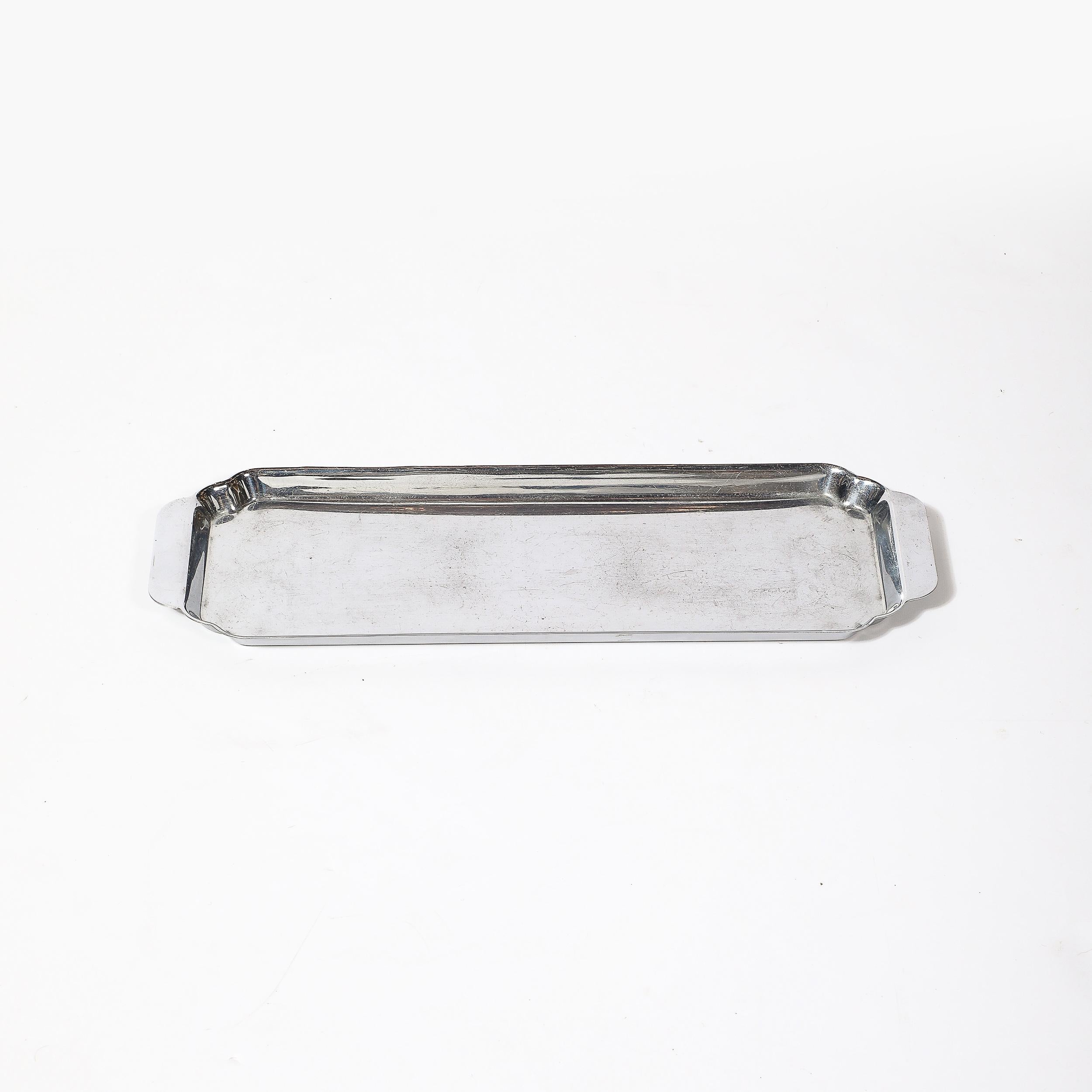 This sleek and sophisticated Art Deco chrome serving tray by Chase is a classic example of the streamlined design ethos that defined the 1930s. Crafted in polished chrome, the tray showcases clean geometric lines and subtle curves that embody the