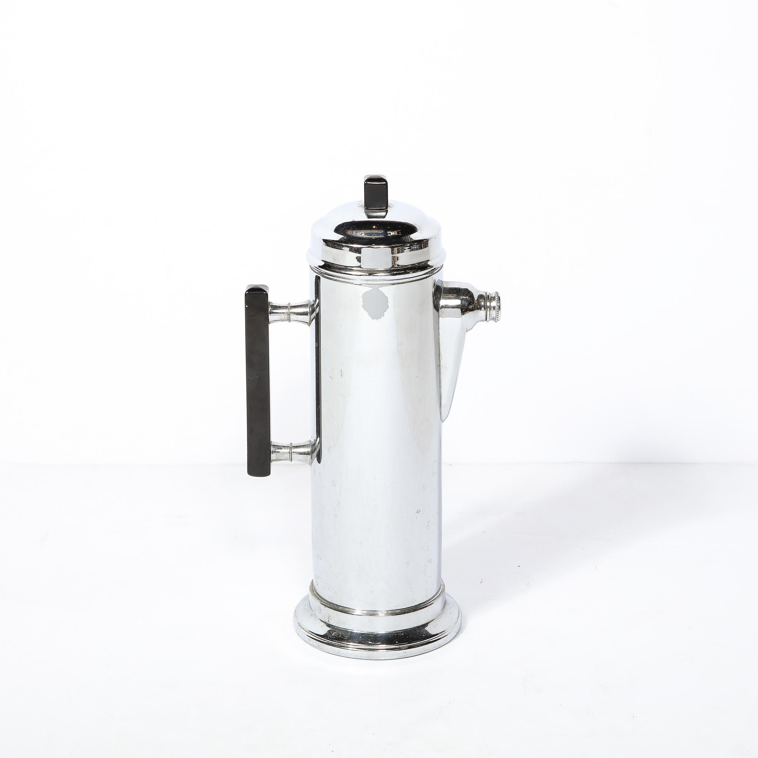 This Art Deco Streamlined Cocktail Shaker in Chrome is an excellent example of streamline design and materials from the era. The piece is rendered in a gorgeous polished chrome and precisely machined Black Bakelite. The Mouth of the Server is capped