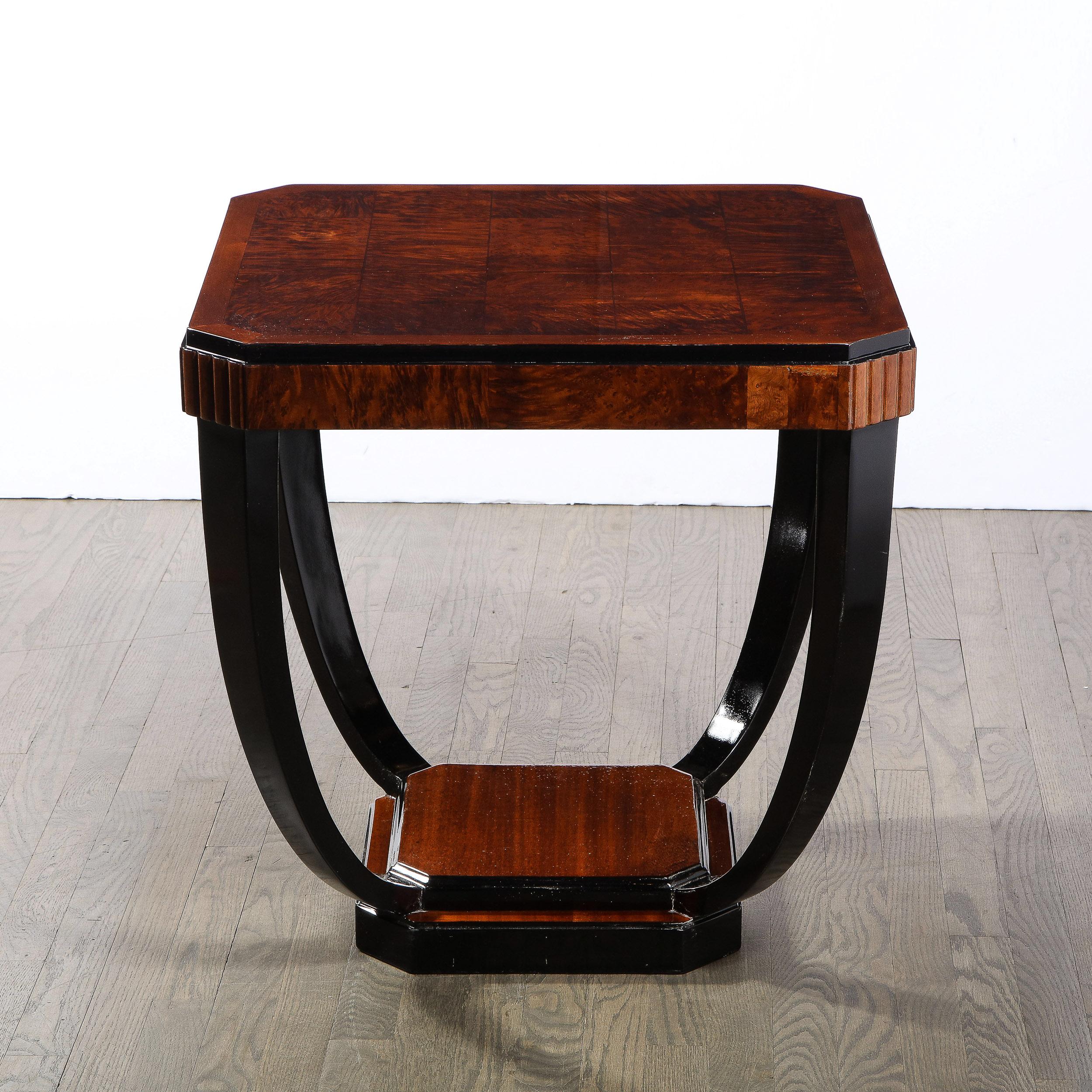 This beautiful Art Deco Machine Age cocktail table was realized in France circa 1935. It feature a skyscraper style base with an octagonal bookmatched walnut bottom wrapped in back lacquer with a smaller concentric form in the same shape and
