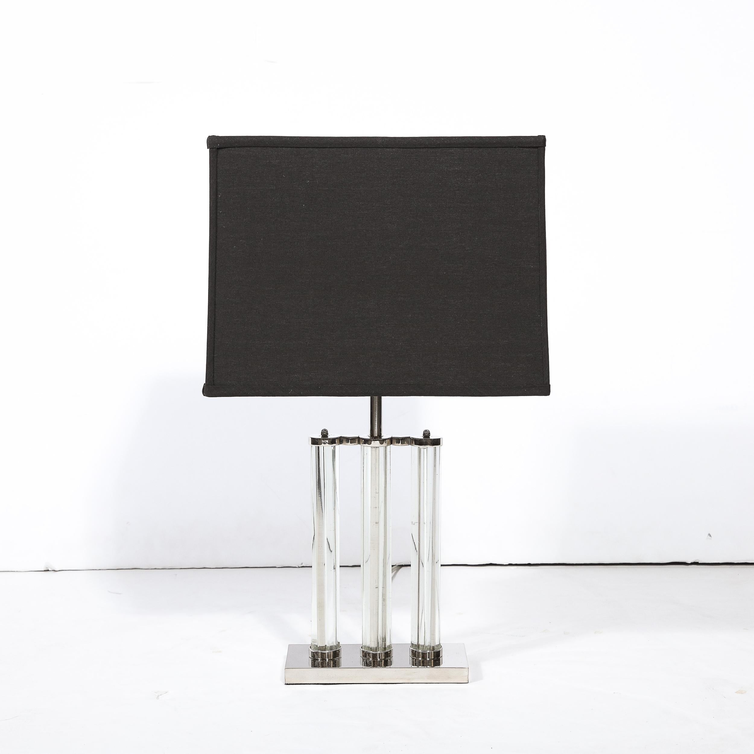 Cette élégante lampe de table Art déco de l'âge des machines a été réalisée aux États-Unis vers 1935. Elle présente une base rectangulaire volumétrique en chrome poli avec trois embellissements cylindriques en relief (dans le même matériau) qui
