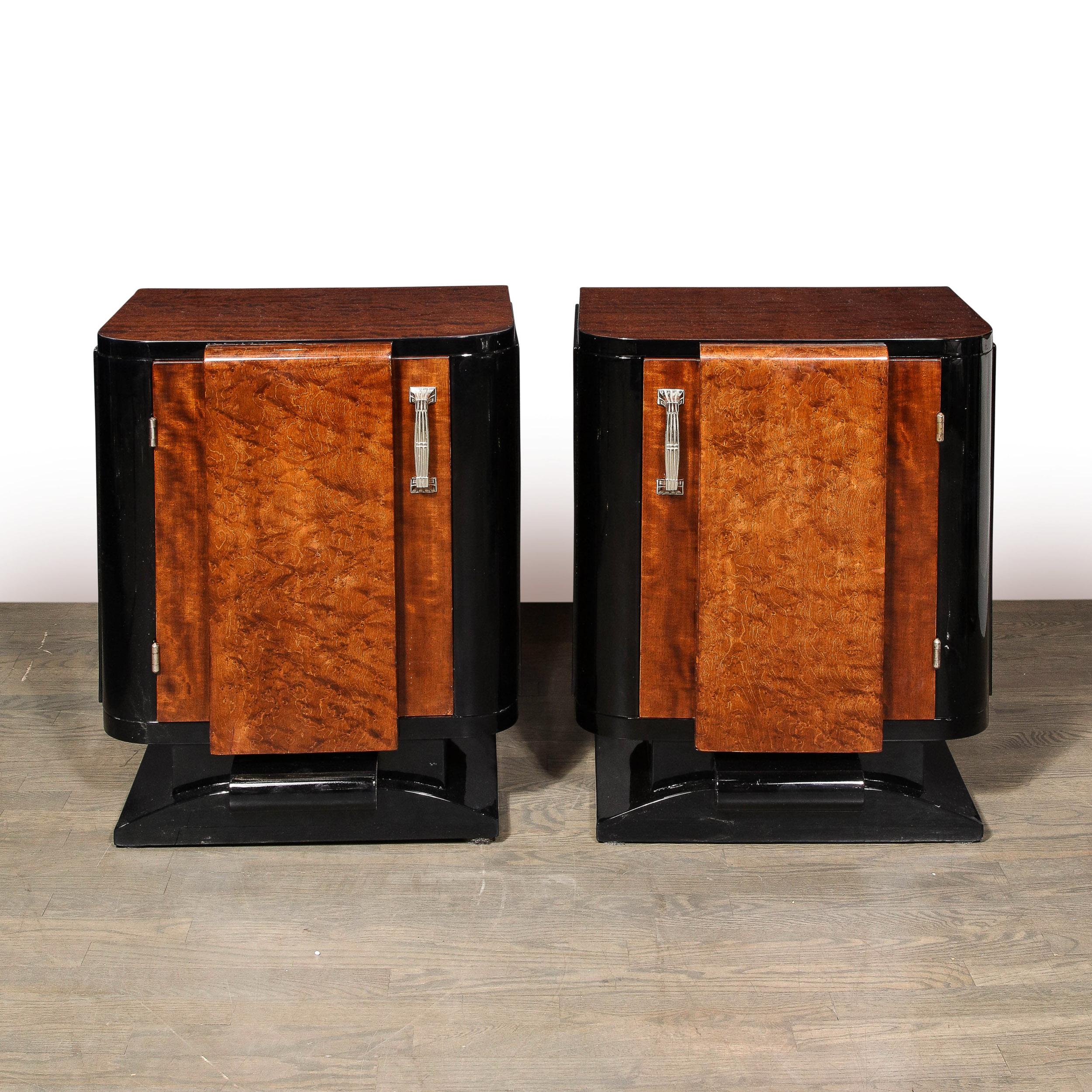This stunning pair of Art Deco Machine Age nightstands were realized in France circa 1935. They feature streamlined bases with a banded detail in the center- all in lustrous black lacquer. The center offers a streamlined rectangular form floating on