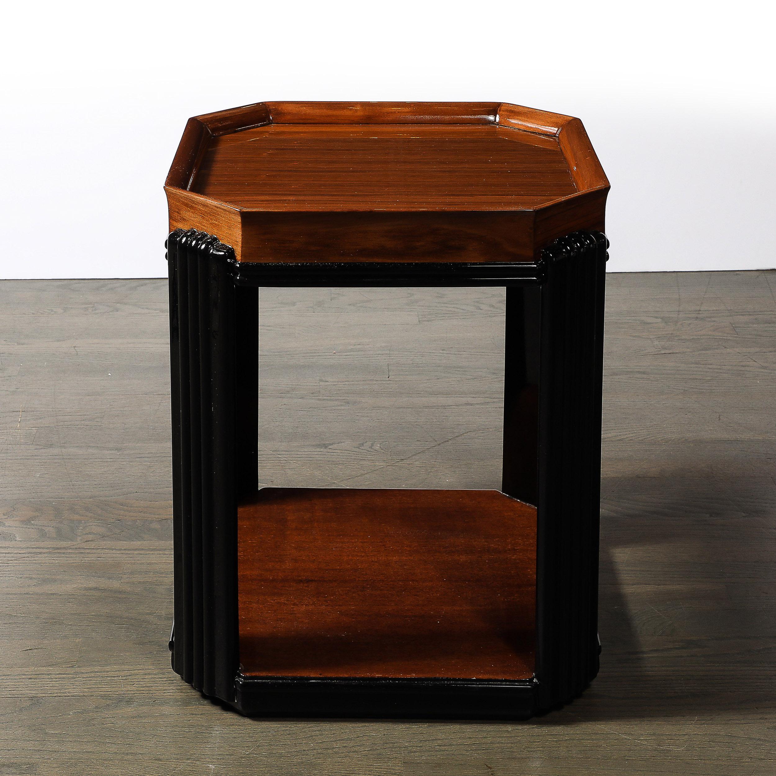 This beautiful Art Deco Streamlined Machine Age Bookmatched Walnut & Fluted Black Lacquer Supports Side Table originates from the United States, Circa 1930. Features an octagonal profile with a curved lip rising from the top surface of the table,