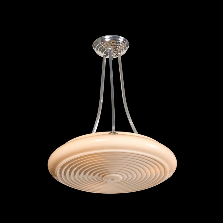 This refined Art Deco Machine Age pendant was realised in Czechoslovakia circa 1935. It features a volumetric saucer form shade in a sumptuous smoked topaz hue with a concentric circular detailing (artfully suggesting rippling water) on its bottom