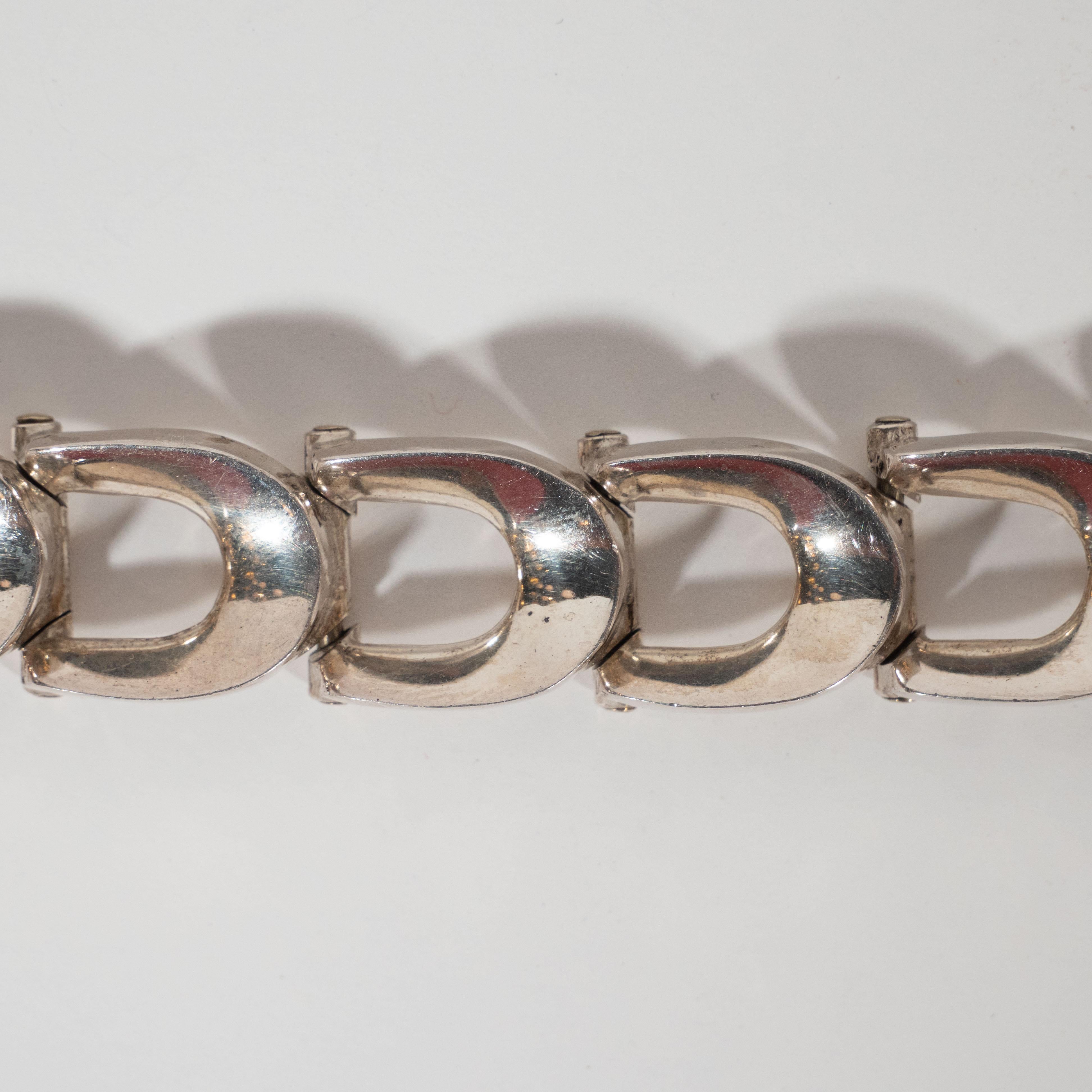 This refined sterling silver bracelet was realized in the United States, circa 1930. It features ten U-form sterling silver links whose streamlined shape epitomizes the period's fascination with speed (air travel, automobiles etc.). With its