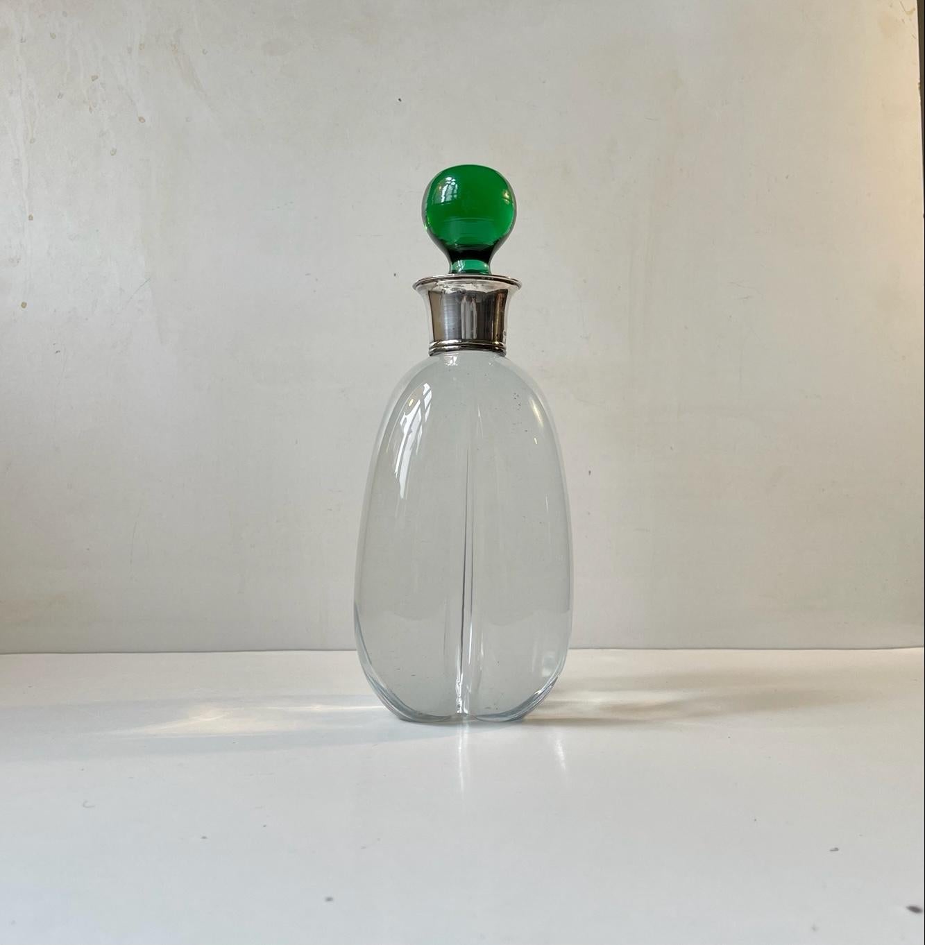 Organically shaped pumpkin decanter in crystal. It is set with a bottle neck in 830/1000 silver designed and made by Carl F. Christensen in Copenhagen Denmark during the 1930s. Fully hallmarked. The green spherical glass stopper may be a later