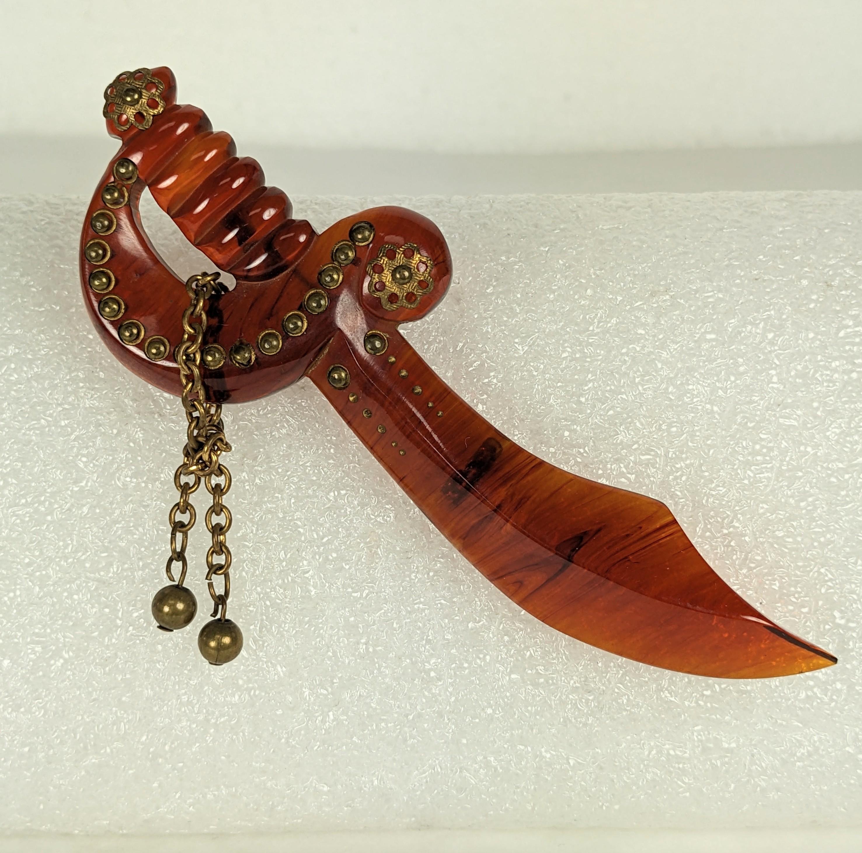 Charmante broche épée en bakélite cloutée Art déco des années 1930. Ensemble en bakélite avec clous en laiton et émail doré. 4.5