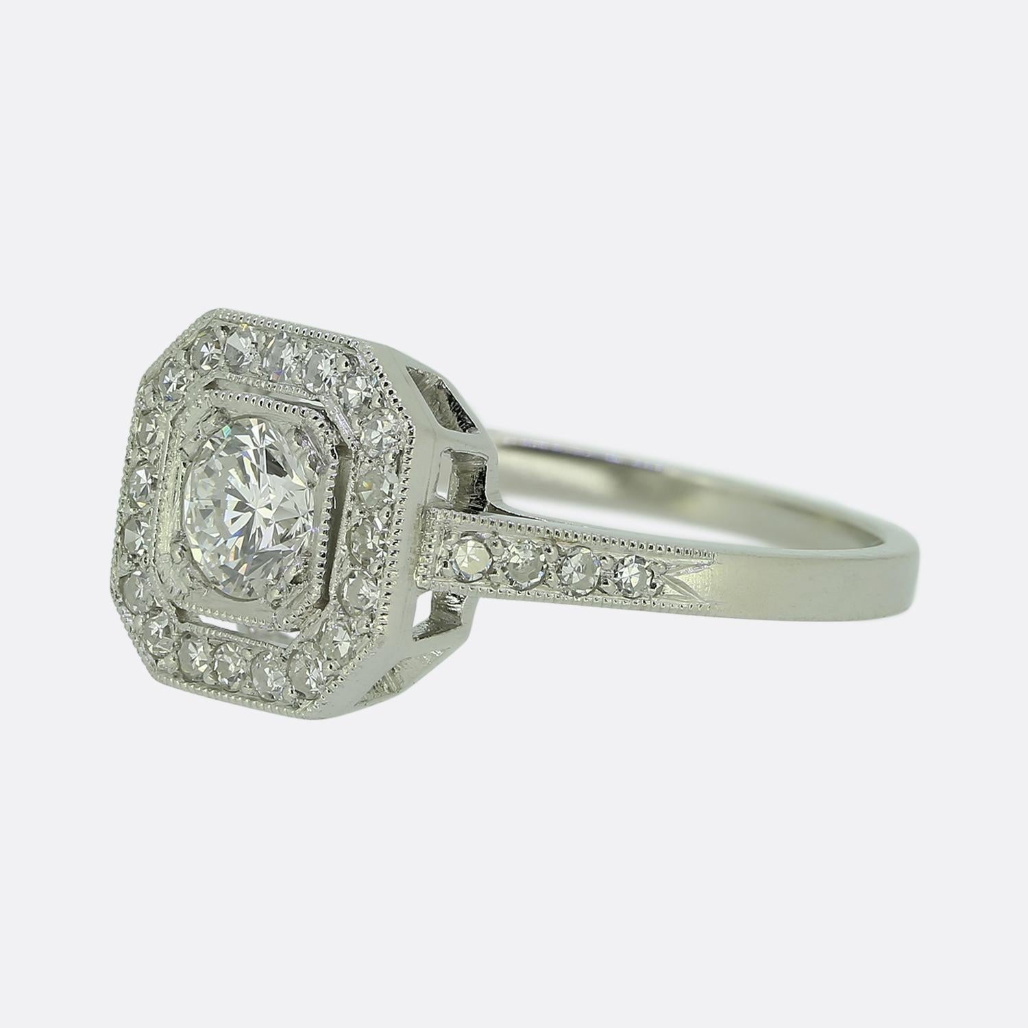 Here we have a wonderful diamond cluster ring. The ring has been masterfully handcrafted in an Art Deco style and features a stunning 0.37 carat round brilliant cut diamond at the centre of the face. This principal stone sits flush in a clawed