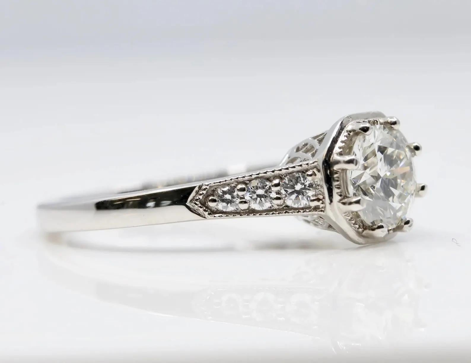 Ein Verlobungsring im Art-déco-Stil mit 0,70 Karat Diamanten aus 14 Karat Weißgold. Im Mittelpunkt des Rings steht ein runder Diamant im Brillantschliff mit 0,70 Karat (Farbe H, Reinheit VS2), umrahmt von sechs akzentuierenden, gepflasterten