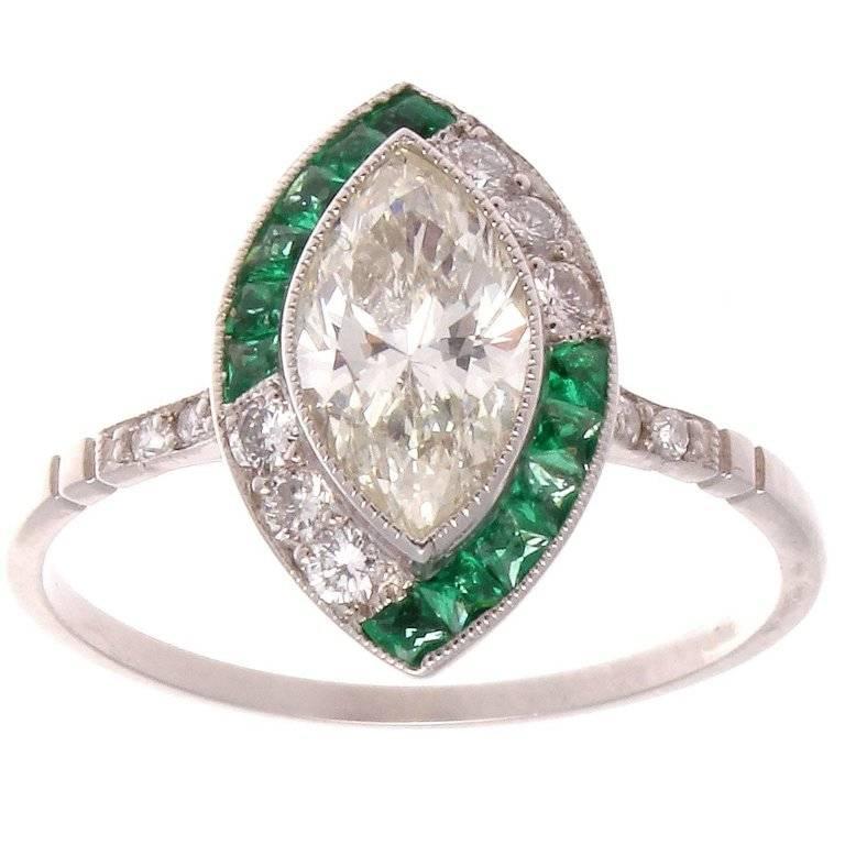 Color blocking with diamonds and emeralds, a new twist on the timeless design aesthetic of the Art Deco style. A beautiful 0.94 carat marquise cut diamond, graded H color, VS clarity, is artfully accented by blocks of French cut emeralds and round