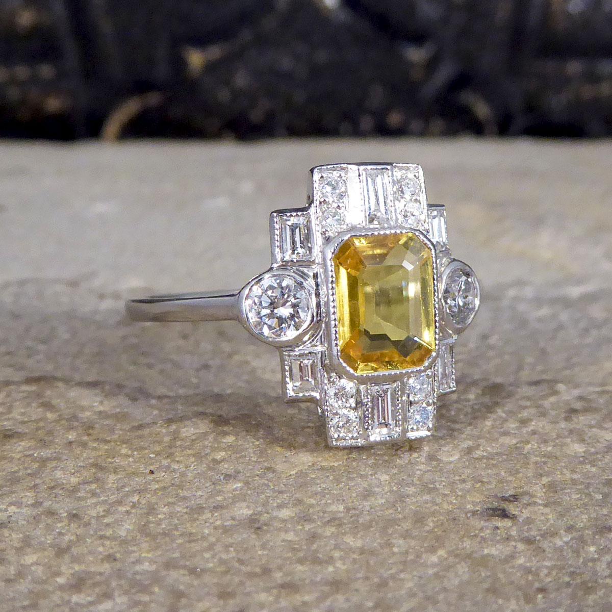 This gorgeous ring is modern but has been crafted in an Art Deco style with very distinct similarities and qualities of this era. Featuring a gorgeous Emerald Cut Yellow Sapphire cut weighing 1.10ct, this ring shows such quality through the