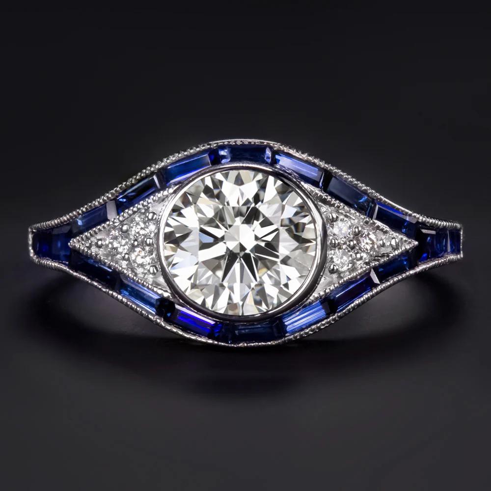 Cette élégante bague inspirée de l'Art déco associe un design intemporel à des couleurs riches et à une géométrie audacieuse. En son centre se trouve un éblouissant diamant rond de taille brillant de 1,21 carat certifié par la GIA, de couleur H et