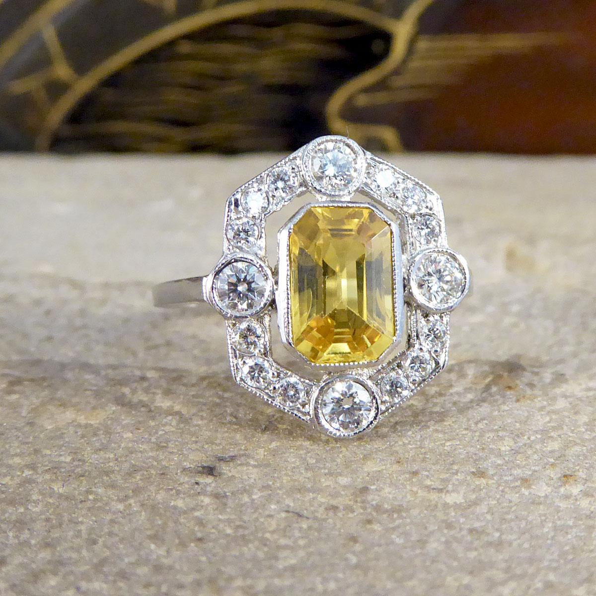 This stunning Contemporary ring has been made to resemble an Art Deco style ring with its geometric halo and setting. It features a single central Octogon Cut Yellow Sapphire stone weighing 1.25ct, surrounded by 16 Brilliant cut Diamonds with a