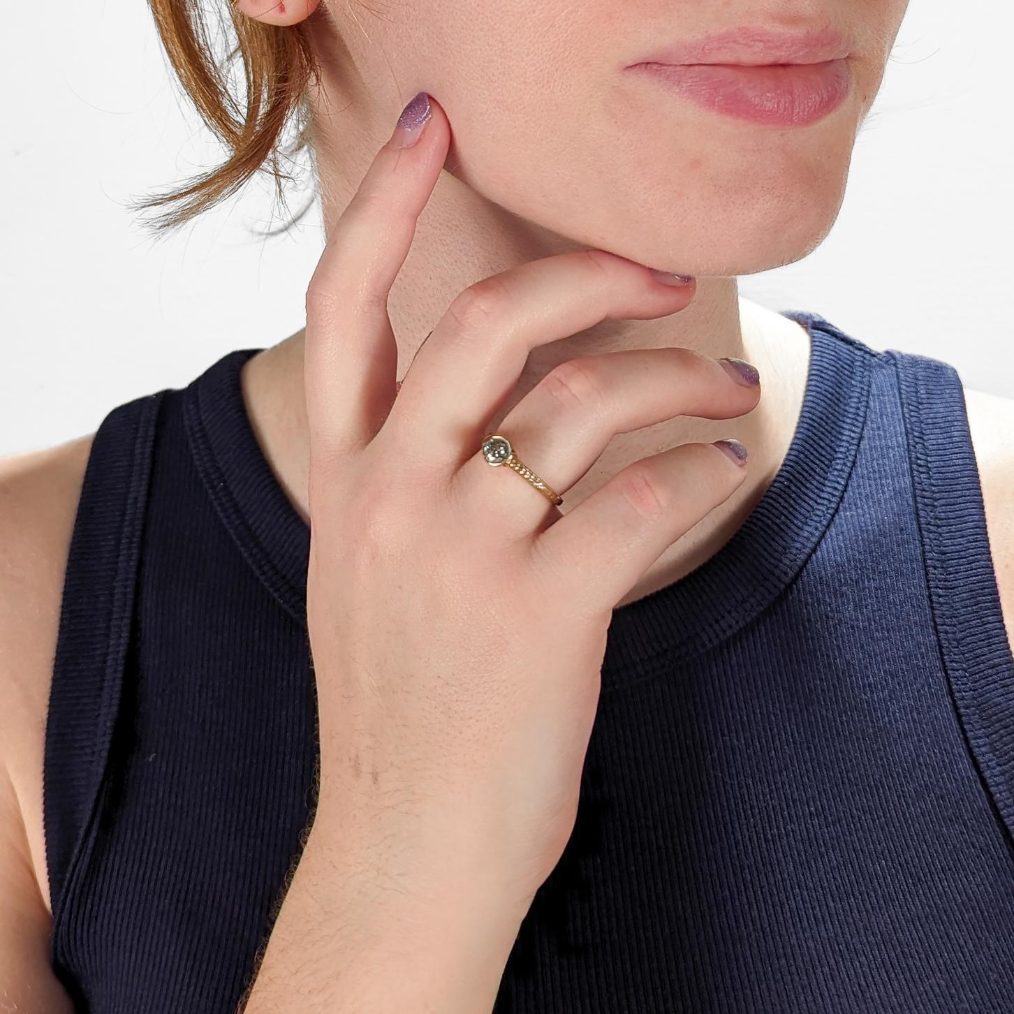 Un raffinato anello solitario in oro e diamanti.

Con un diamante rotondo taglio brillante incastonato in un'incastonatura a filigrana a cestello alto in stile Art Déco, supportato da una fascia incisa. 

Il diamante misura circa 0,47 ct. (Colore:
