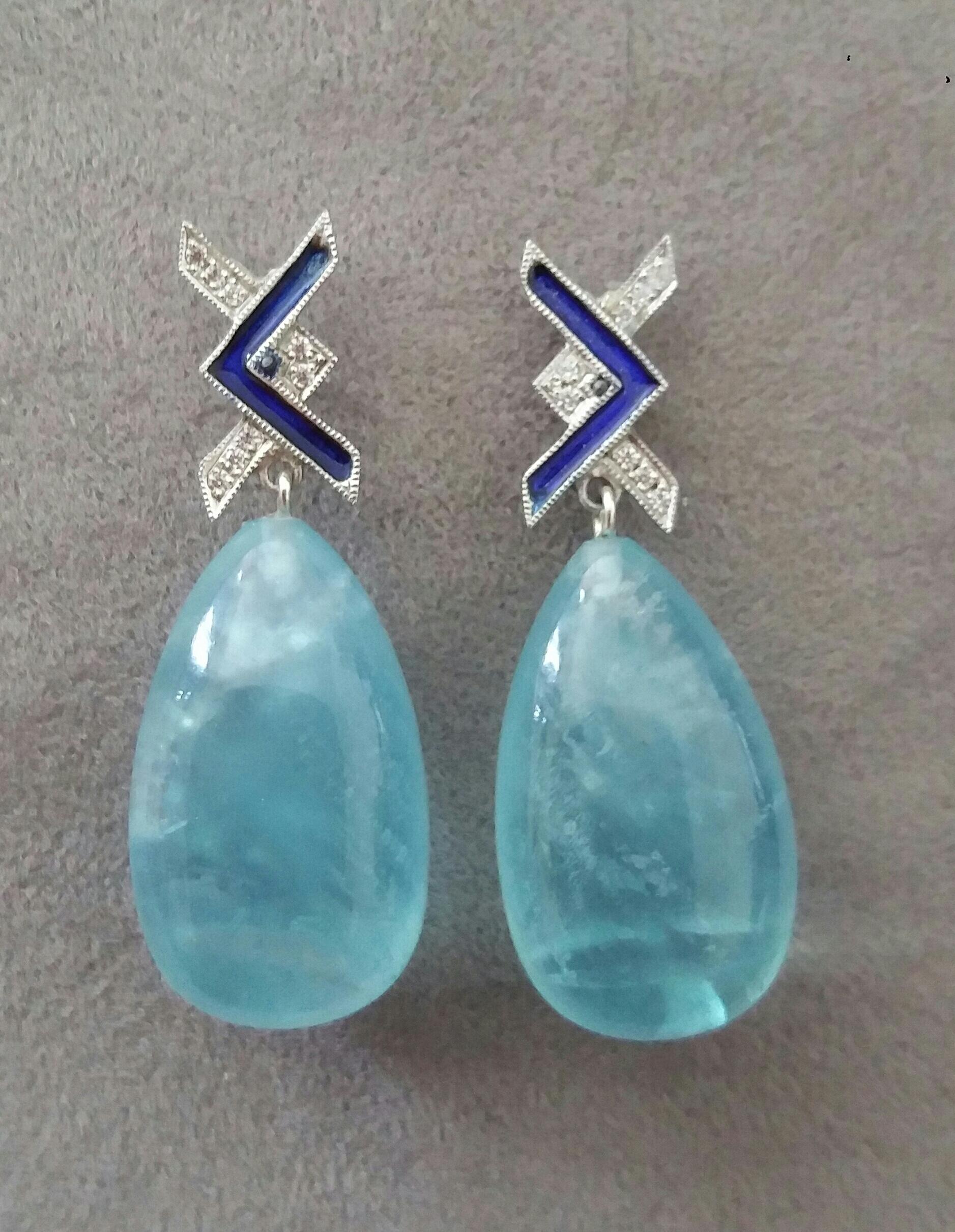 In questi orecchini fatti a mano in stile Art Deco, 2 gocce semplici di acquamarina naturale di ottima qualità che misurano 14 x 23 mm. sono sospese a 2 punte in oro bianco 14 kt.  con 16 diamanti rotondi a taglio pieno e smalti blu.

Nel 1978 il