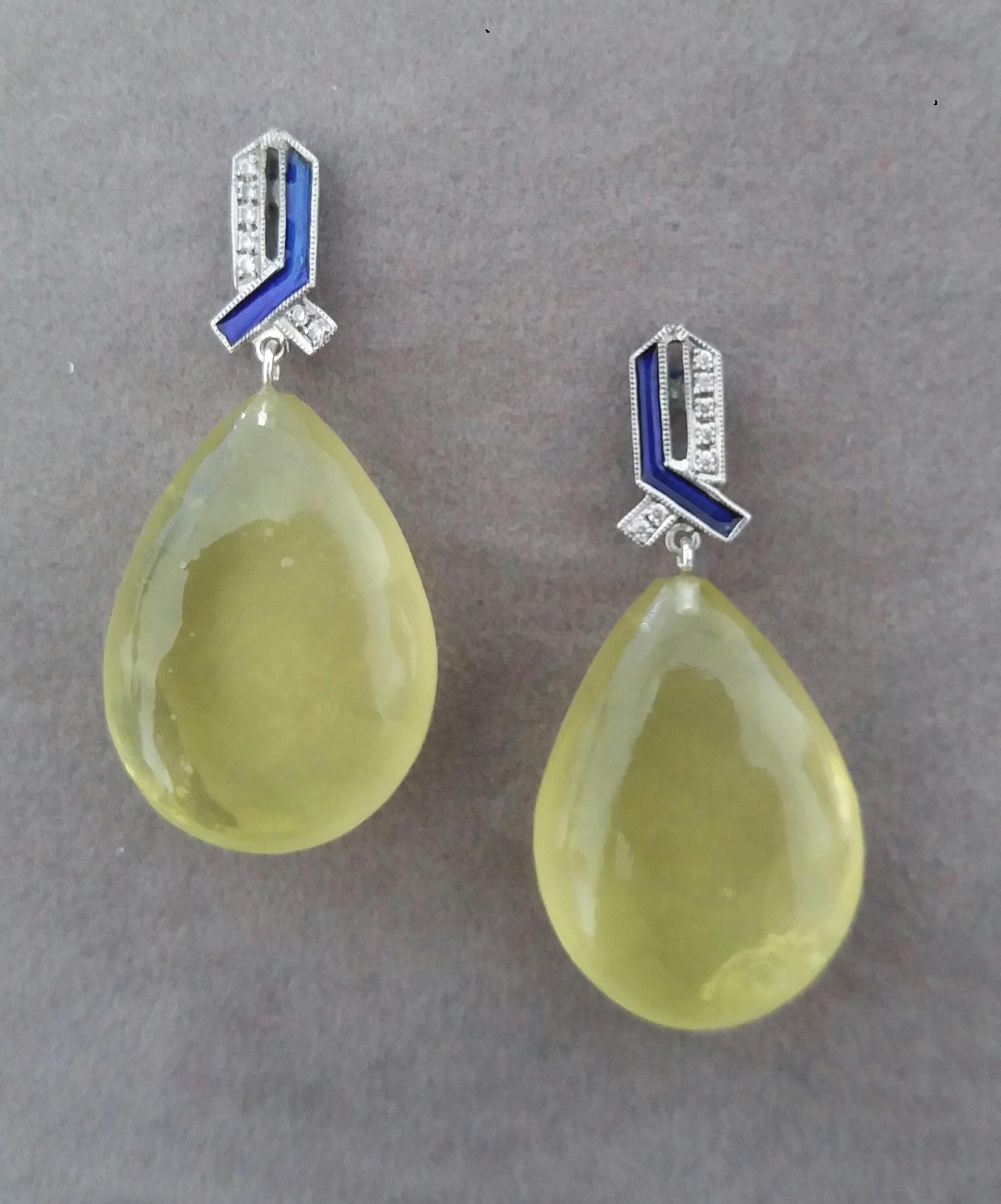 In these Art Deco Style handmade earrings 2 very good quality Natural Lemon Quartz plain drops measuring 18 x 26 mm. are suspended from 2 white 14 kt gold elements tops  with 16 full cut round diamonds and blue Enamels.

In 1978 our workshop started