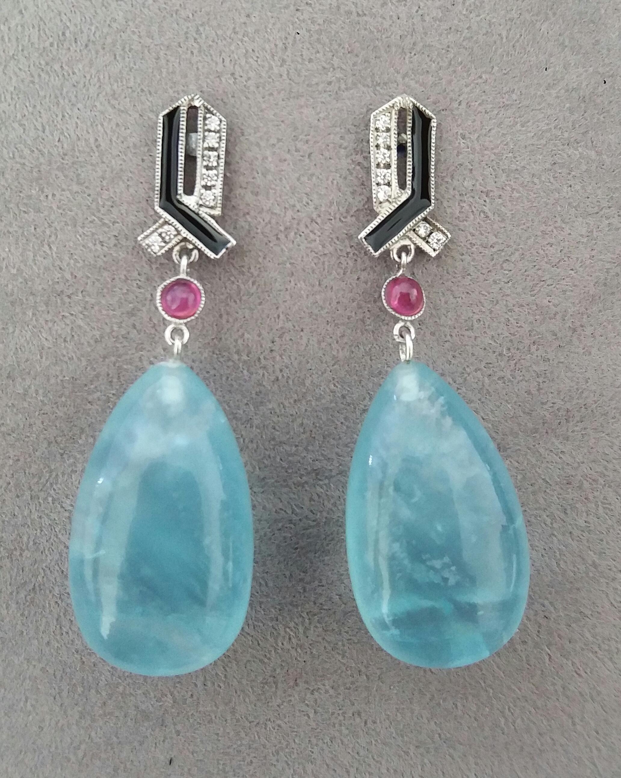 In these Art Deco Style handmade earrings 2 very good quality Natural Aquamarine plain drops measuring 14 x 23 mm. are suspended from 2 small round Ruby cabochons  and 2 white 14 kt gold tops  with 16 full cut round diamonds and blue Enamels.

In