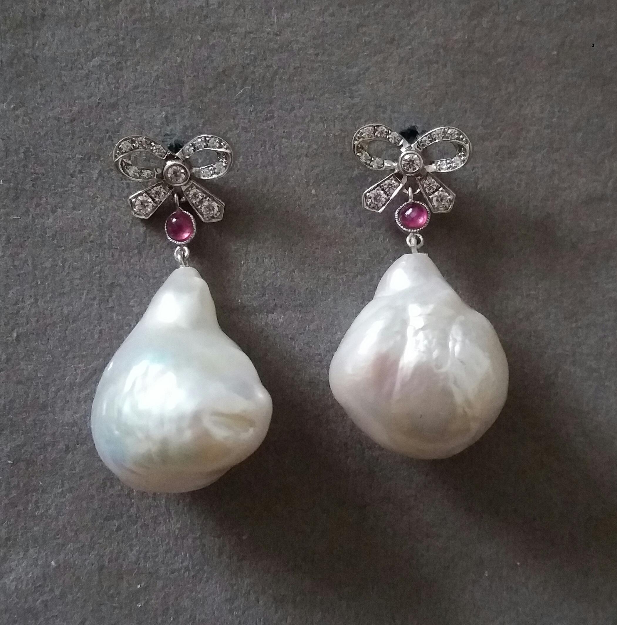 In these classic Art Deco Style earrings the tops are 2 White Gold and Diamonds  Bows, 28 round full cut diamonds and 1 pair of small round Ruby cabs ,in the lower parts we have 2 White Pear Shape Baroque Pearls in High Luster and Unique Big