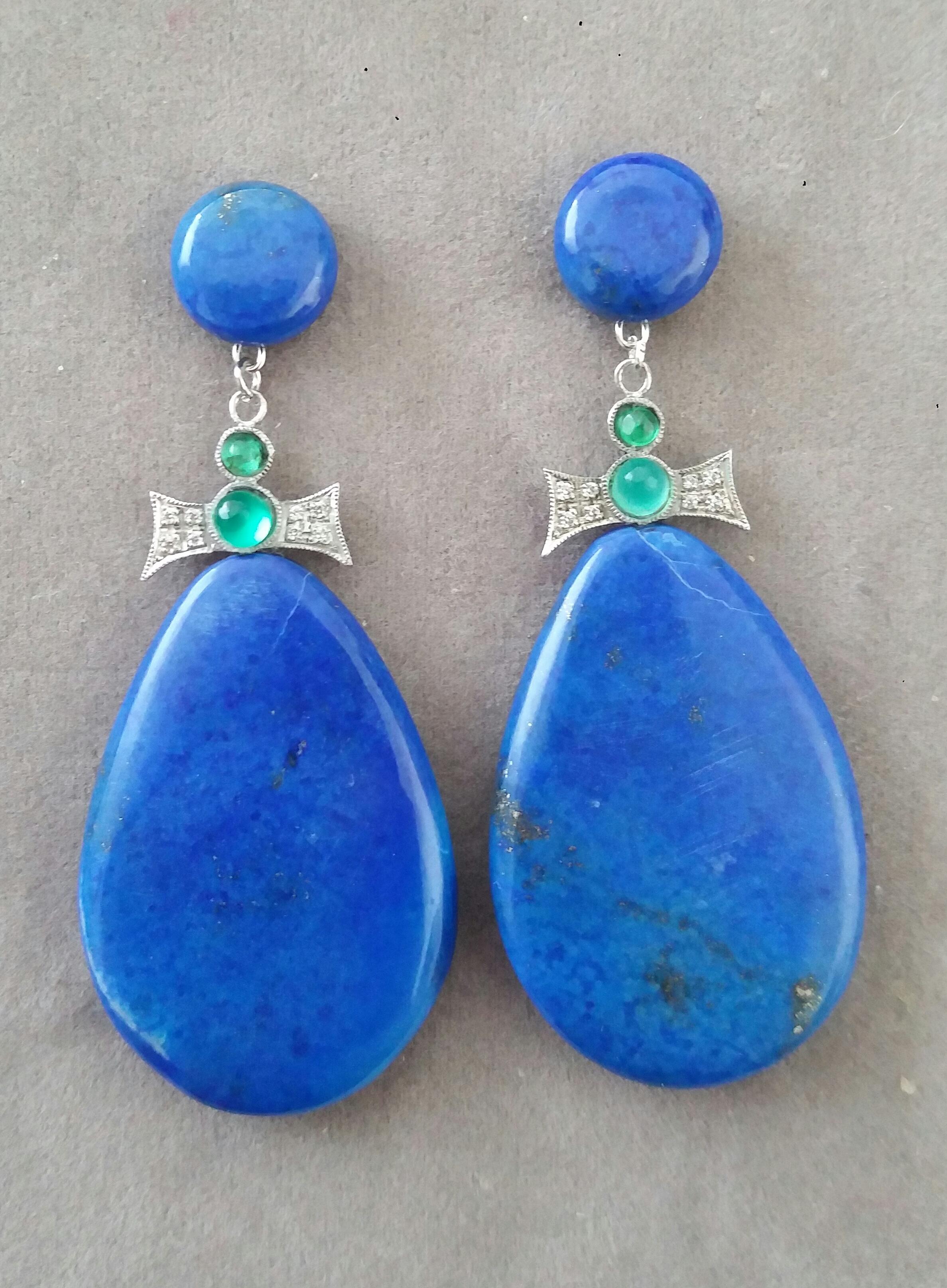 In these Art Deco Style handmade earrings 2 good quality Natural Lapis Lazuli plain drops measuring 25 x 37 mm. are suspended from 2 bow shape 14 kt white gold elements with 16 full cut round Diamonds and 4 Emerald small round cabohons.The top parts