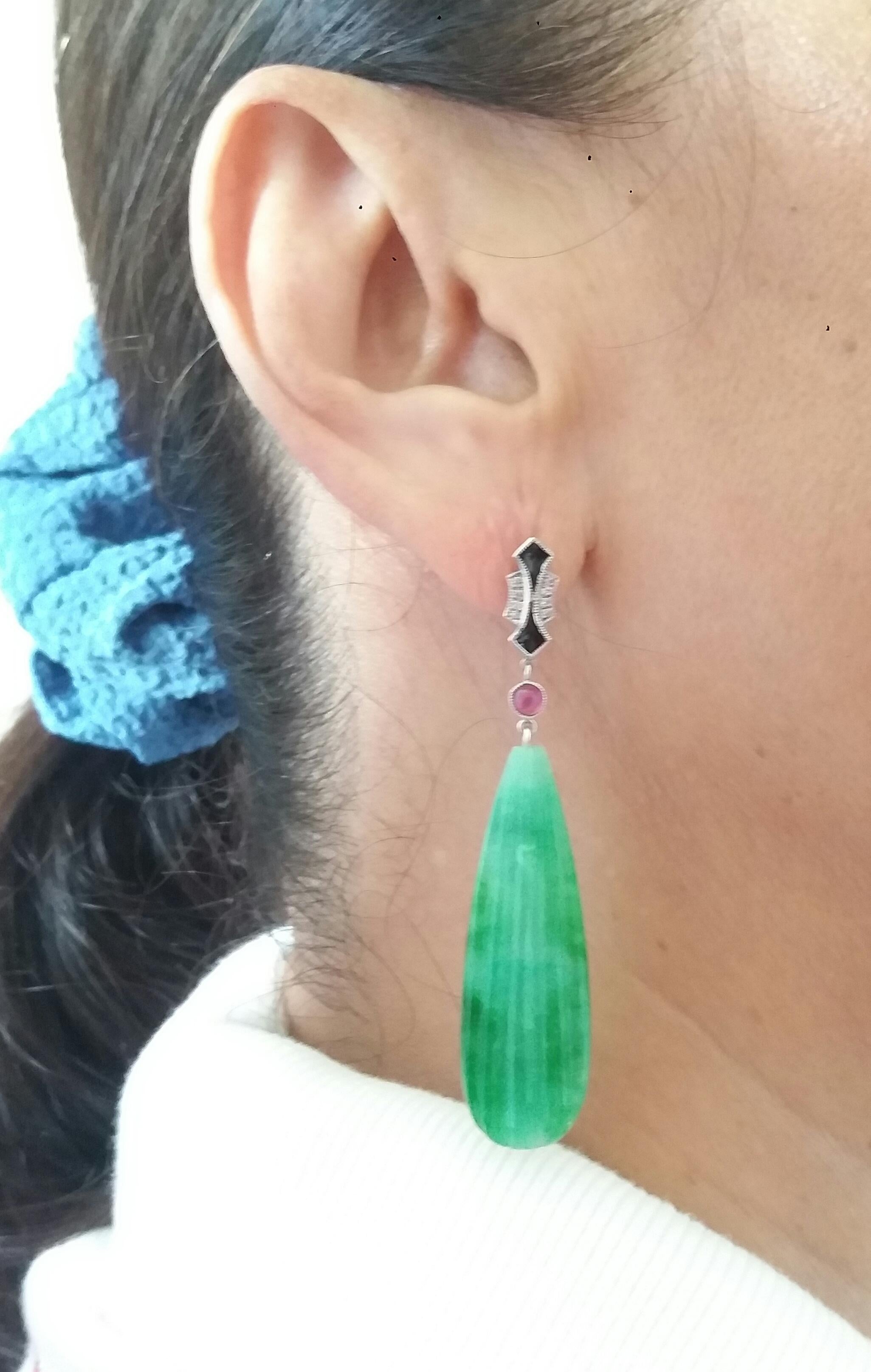 In these classic Art Deco Style earrings the tops are 2 parts  in 14 kt.white gold, 16 round full cut diamonds,small round Ruby cabs and black enamel ,in the lower parts we have 2 Engraved Burma Jade  flat drops measuring 13 x 41 mm
In 1978 our