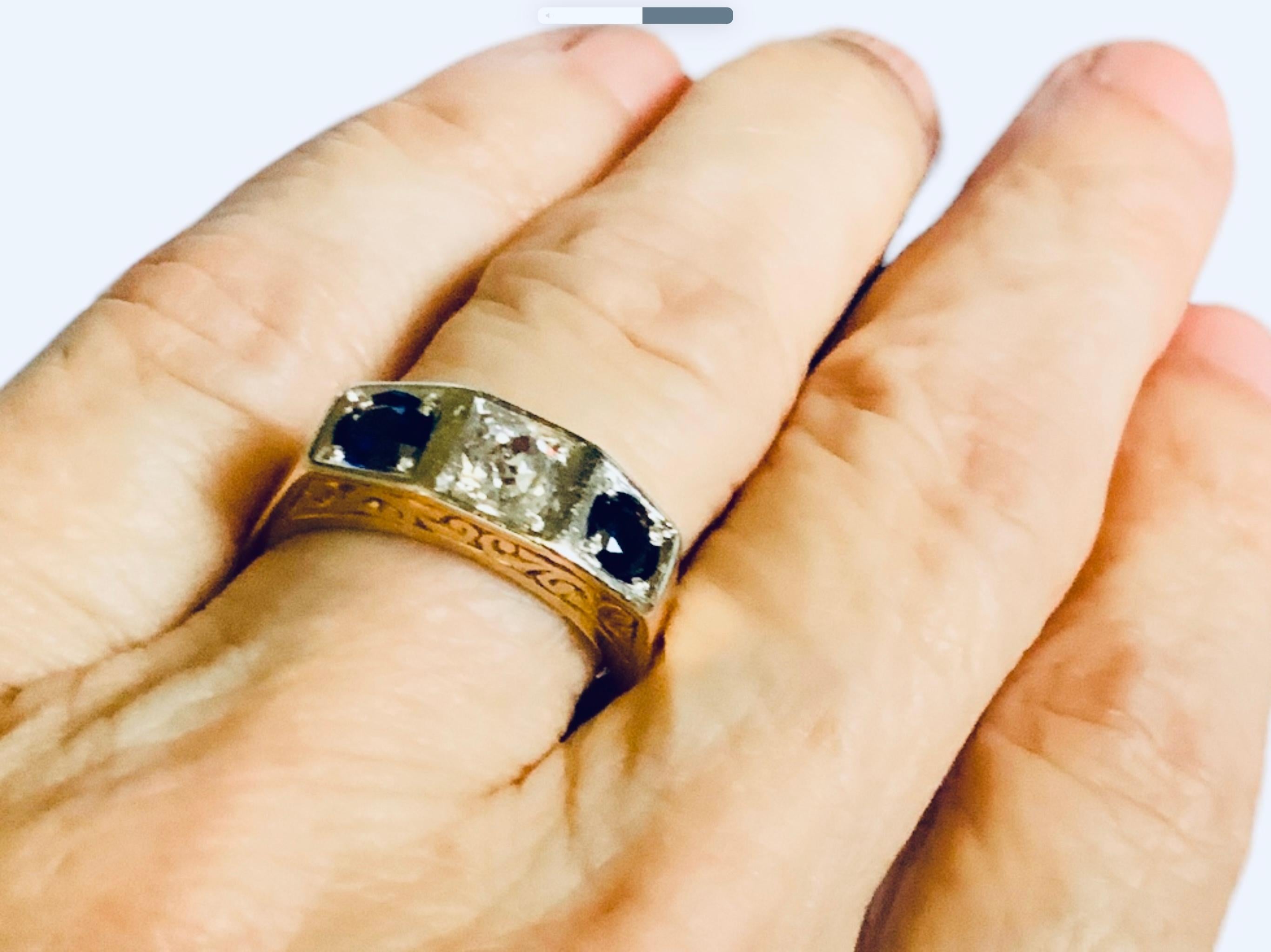 Dies ist ein Art Deco 14K Gelbgold, Diamant und Saphir Strumpfband Ring. Es zeigt einen goldenen Ring mit einer Spitze, die durch zwei kleine Quadrate an den Seiten und ein größeres in der Mitte geteilt ist. Die Mitte wird von einem alten