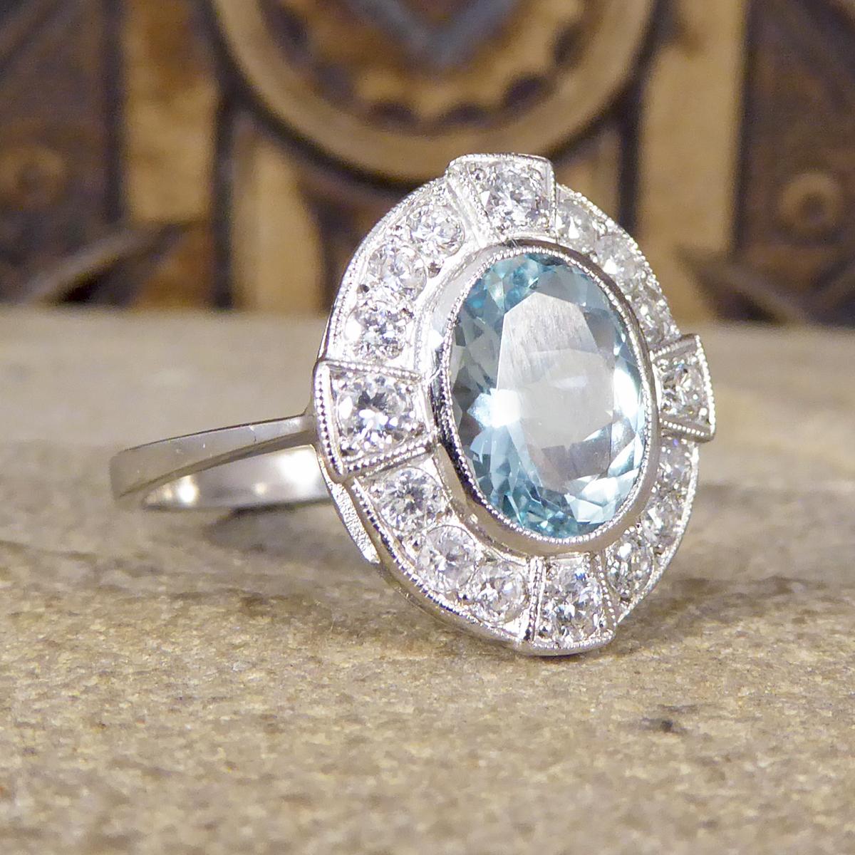 This ring has been crafted to resemble an Art Deco style from Platinum. Featuring a 1.50ct Oval Cut Aquamarine in the centre of the ring in a rub over collar setting with a millegrain edge detail, and Diamonds circling the Aqua graduating in size.