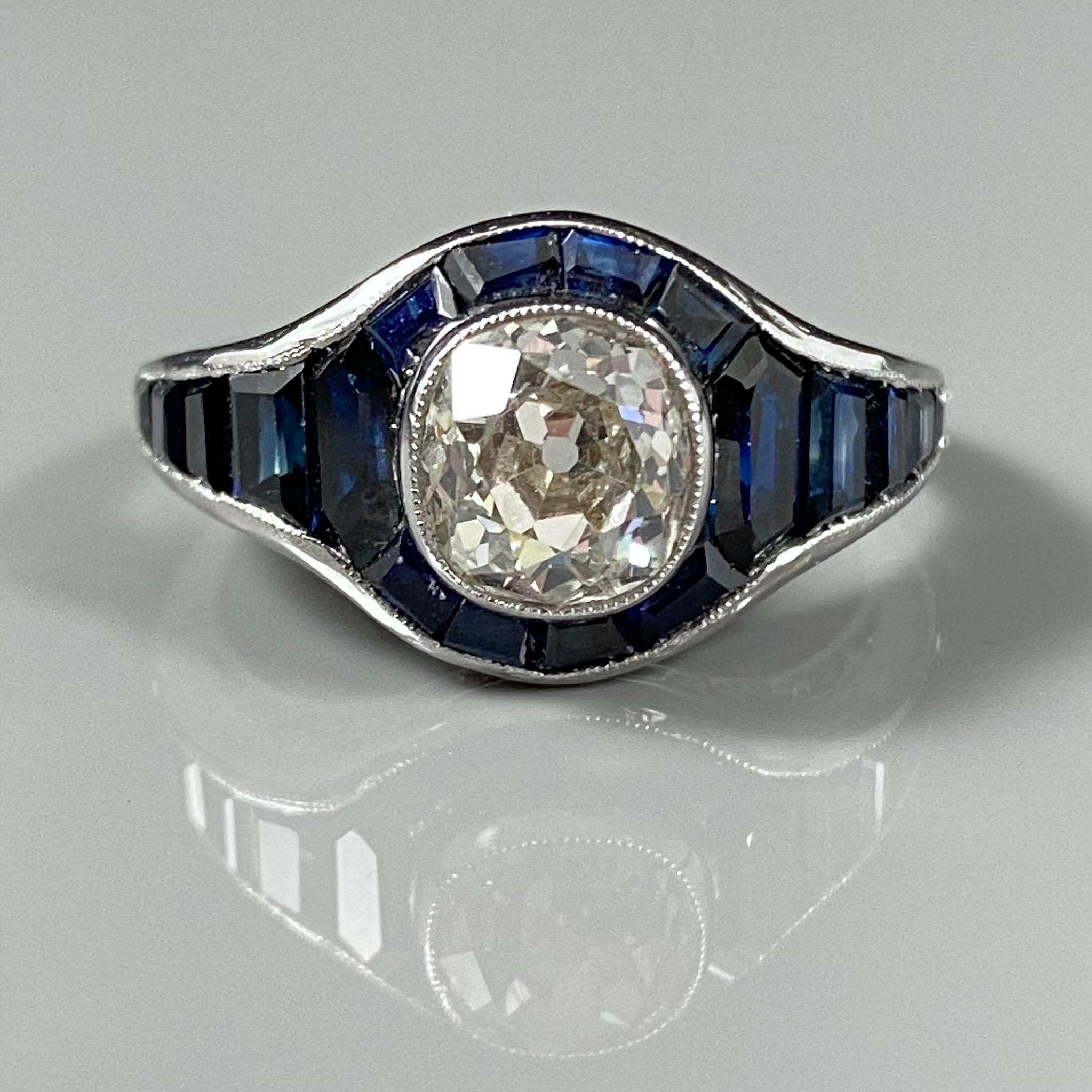 Art Deco style 1.80-carat Old Mine-cut diamond and sapphire engagement ring in platinum, vintage from circa 1990. This jewel of bombé cluster design features a charming Old Mine-cut diamond millegrain-set to the center, surrounded by a halo of