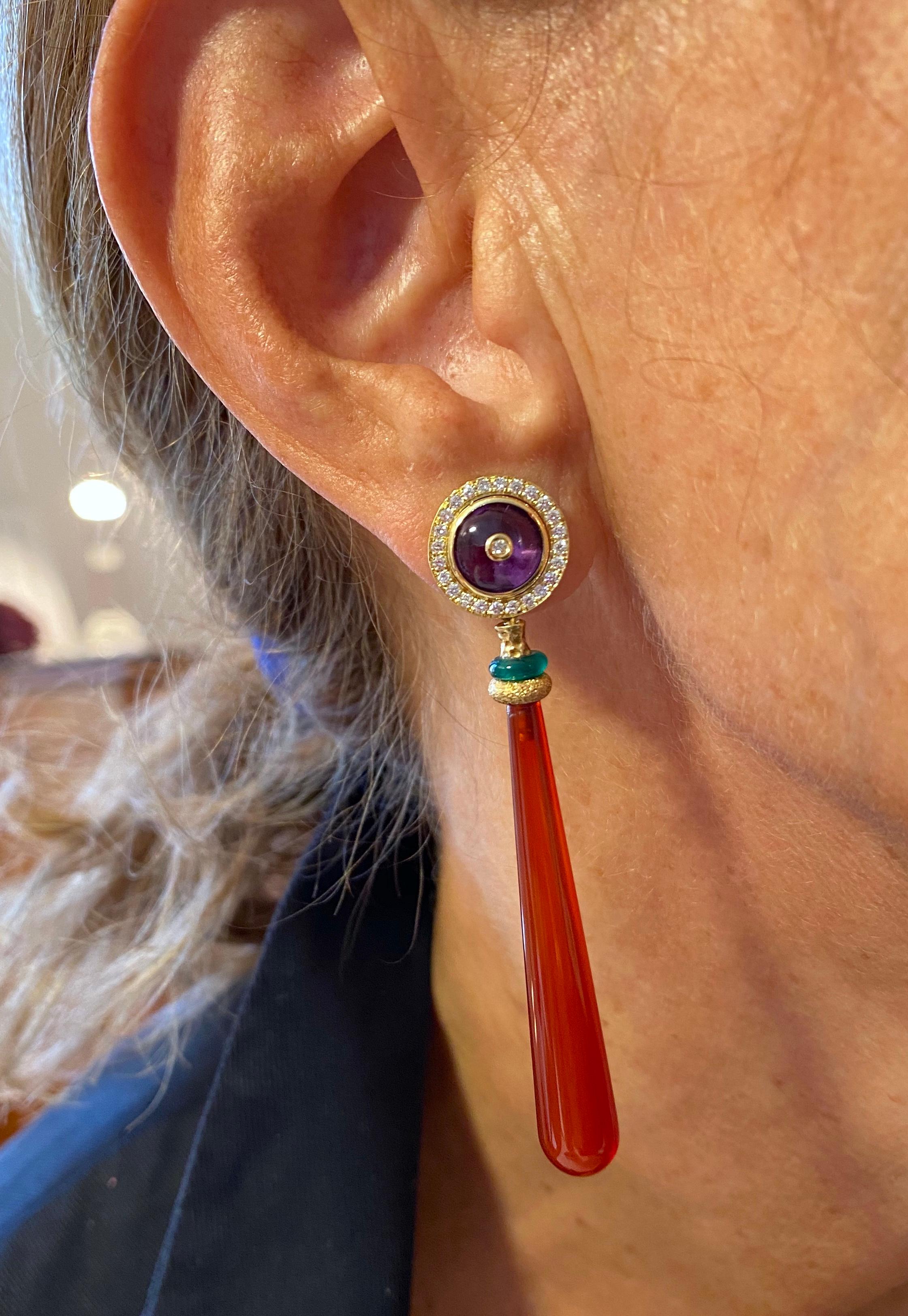 Rossella Ugolini Design Collection, A round amethyst with a single diamond in the center set in 18k yellow gold bezel and surrounded by 0,40 carat of white diamonds ...
A dangling drop carnelian lies with green agate in hammered yellow gold.
This