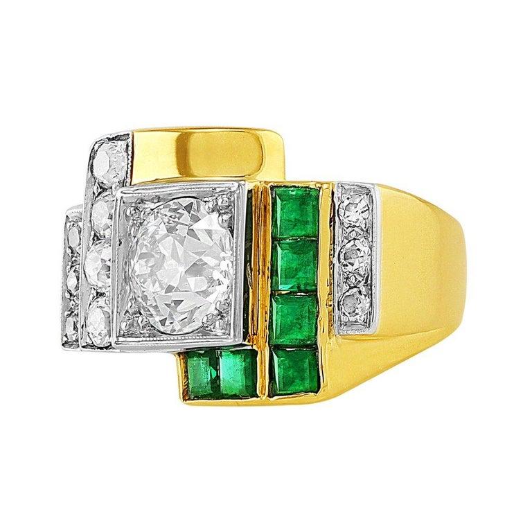 Striking 18k yellow gold estate art deco style ring set with a center round brilliant cut diamond weighing 2.27cts and SI1 clarity, side diamonds and emeralds. The side diamonds weigh approximately 0.64cttw and the emeralds weigh approximately
