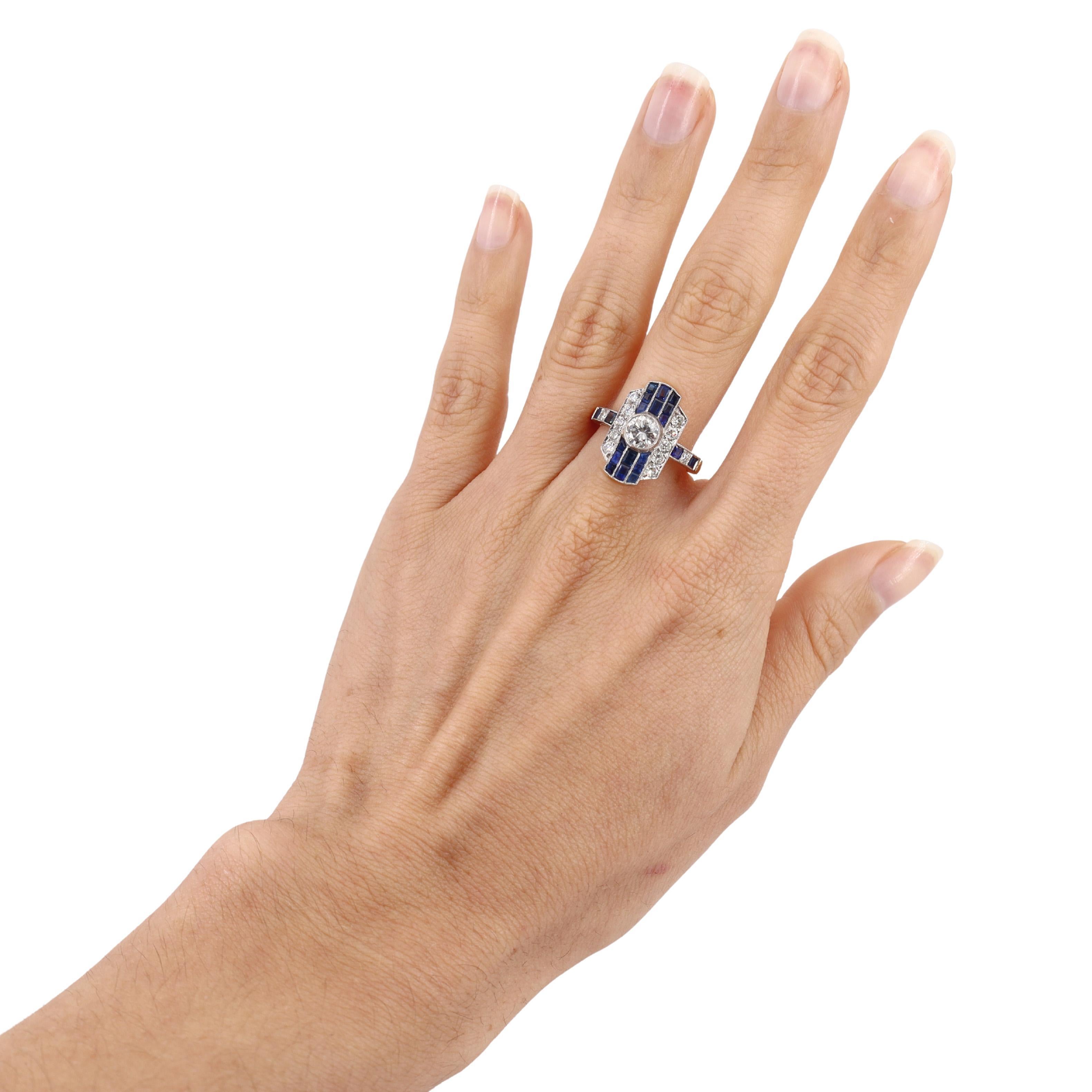 Ti presentiamo un anello mozzafiato in stile Art Déco meticolosamente realizzato in oro giallo 18 carati con una lussuosa parte superiore in platino. Il cuore di questo gioiello è costituito da uno splendido diamante a taglio rotondo di circa 0,60
