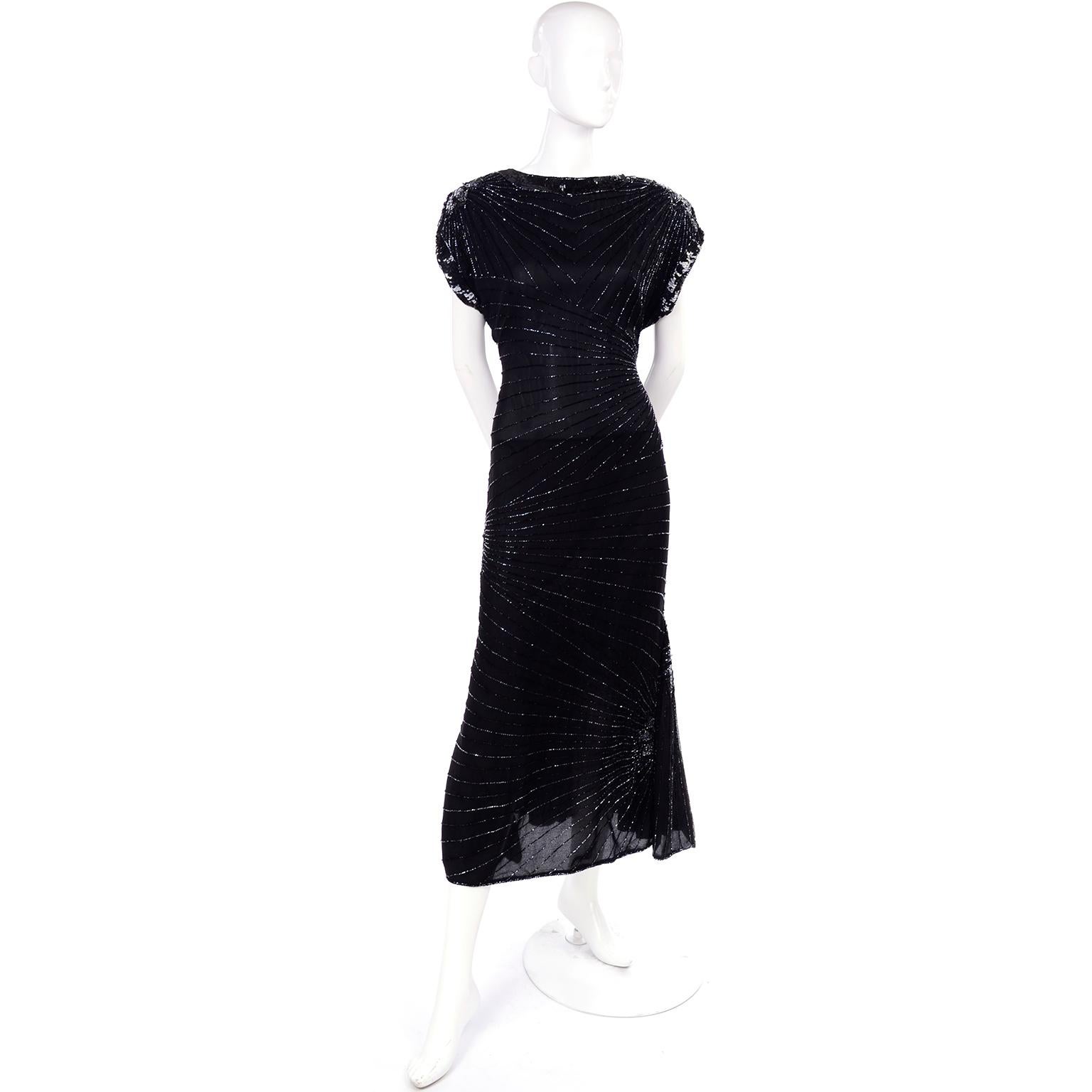 This is a sensational vintage 100% silk black dress, lined in rayon, from the 1980's. The 1920s/30s style 80's dress zips up the back with an exaggerated keyhole opening, and a hook and eye at the neck. There is lovely sequin trim and we love the