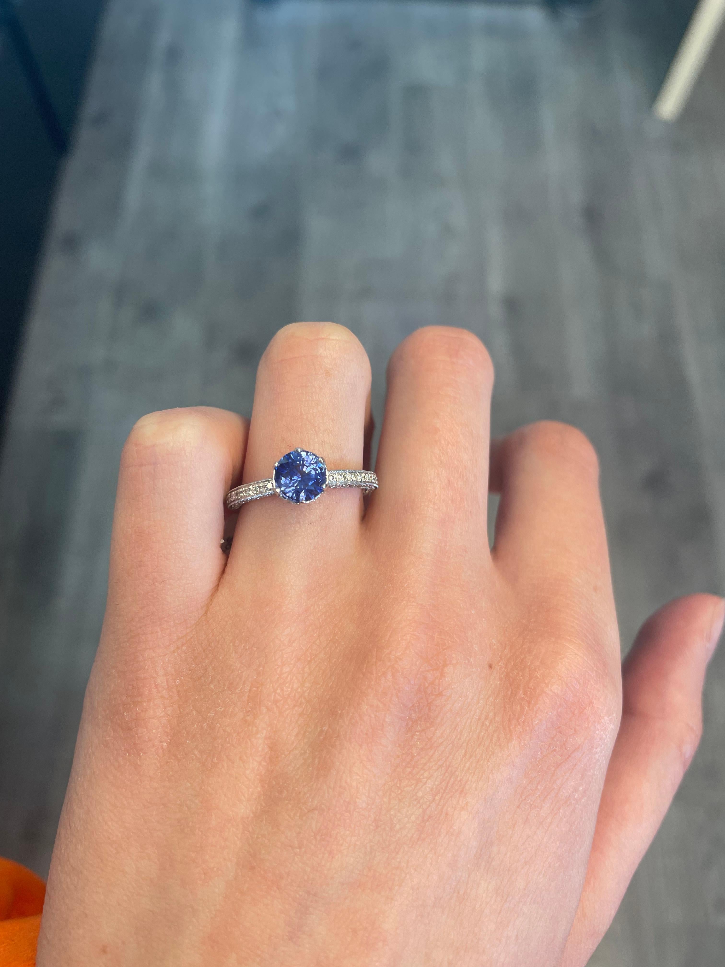 Art Deco style round Ceylon sapphire ring with diamonds.
1.99 carats total gemstone weight.
Center 1.53 carat round Sri Lankan sapphire, heat. Complimented with 0.46 carats of round brilliant diamonds, approximately G/H color and SI clarity. 18k
