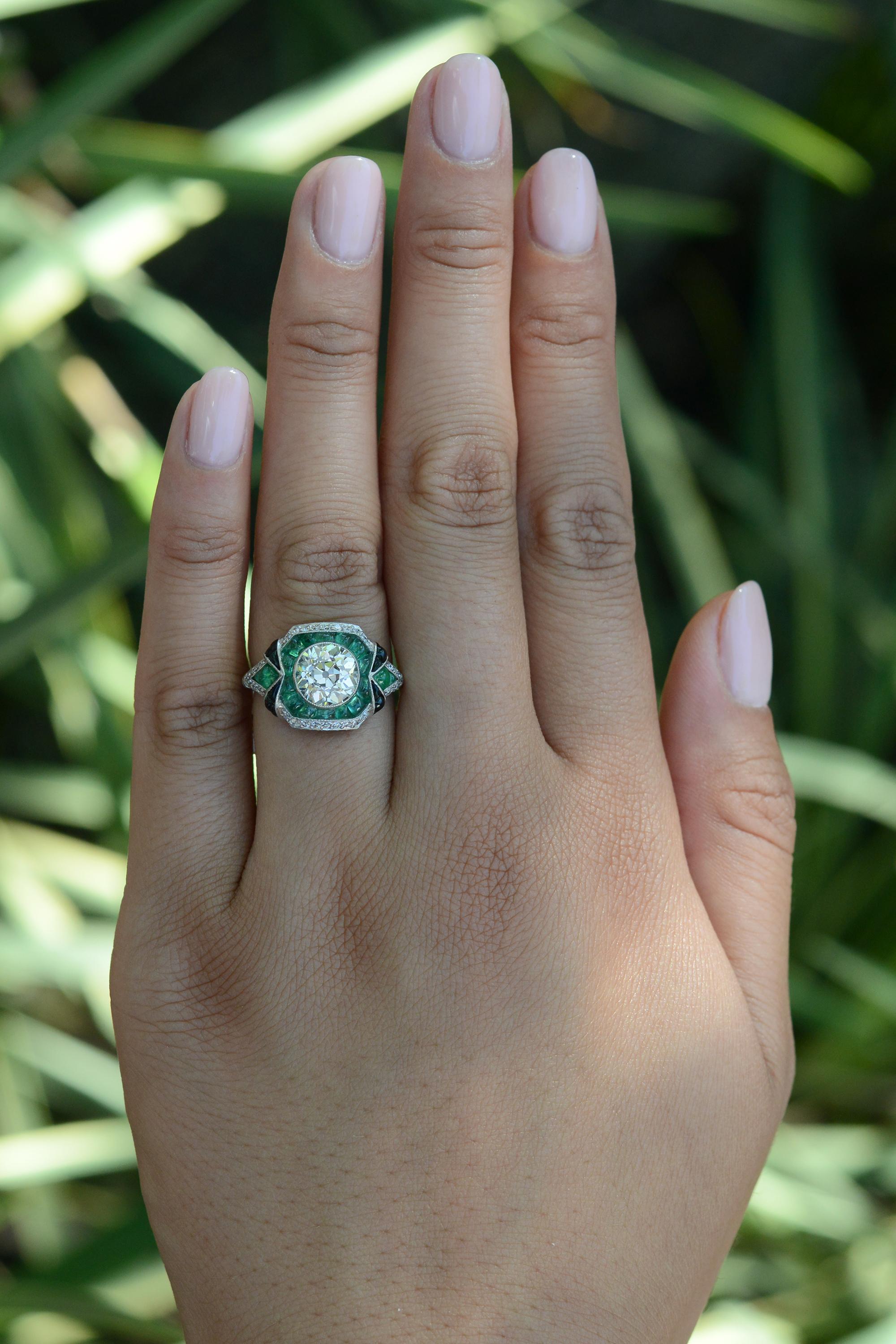 This sensational Art Deco inspired engagement ring has a trio of gemstones that have come to be our favorite combination; diamond, emerald, and onyx. There is something so special about the way the dazzling antique diamond contrasts with the mystic