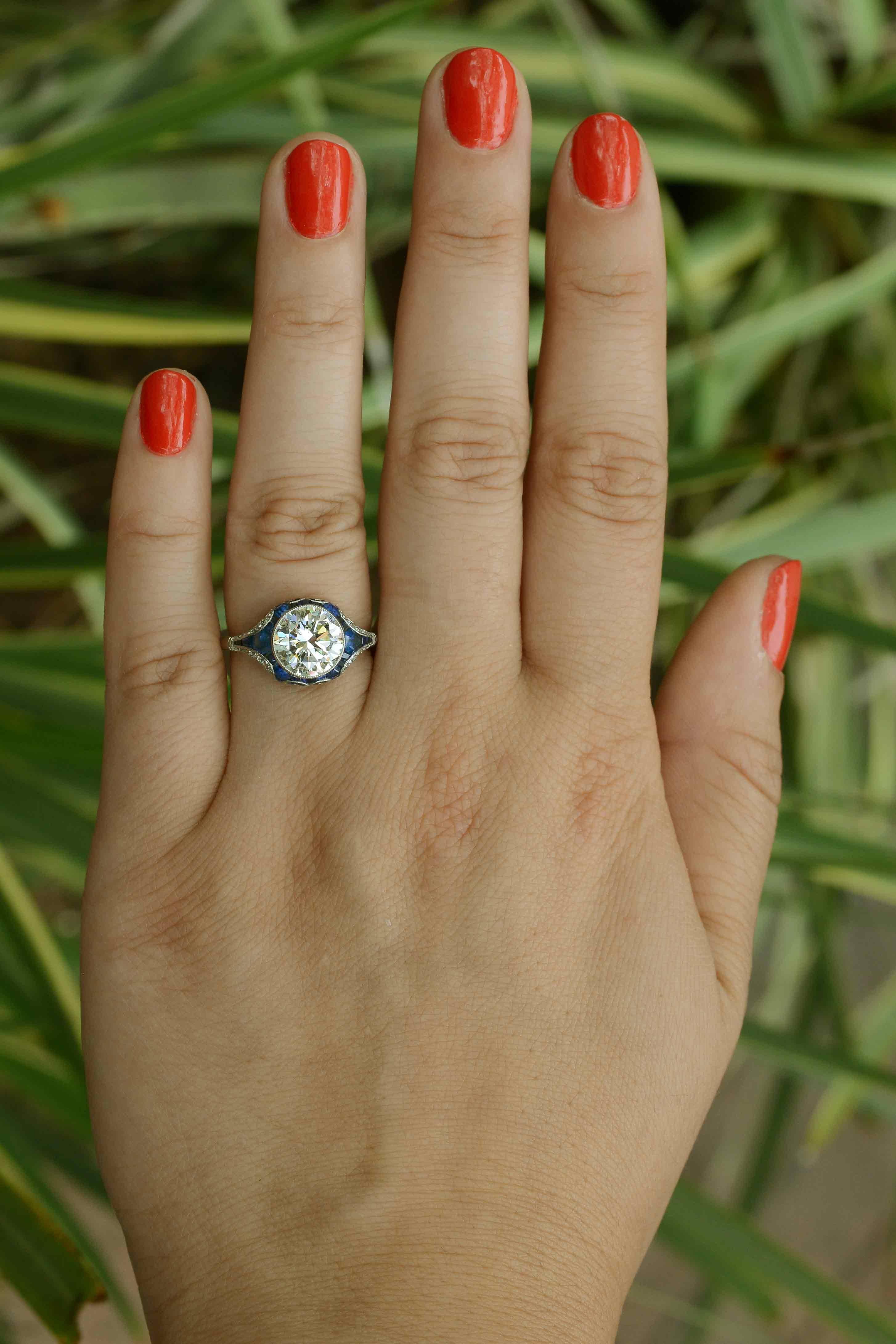 Ein frecher und gewagter Verlobungsring mit Diamanten und Saphiren im Stil des Art Deco. Der zentrale, große, runde Brillant von 2,34 Karat besticht durch seine VVS-Klarheit und seine fabelhafte Facettierung. Der mit französischen und kalibrierten