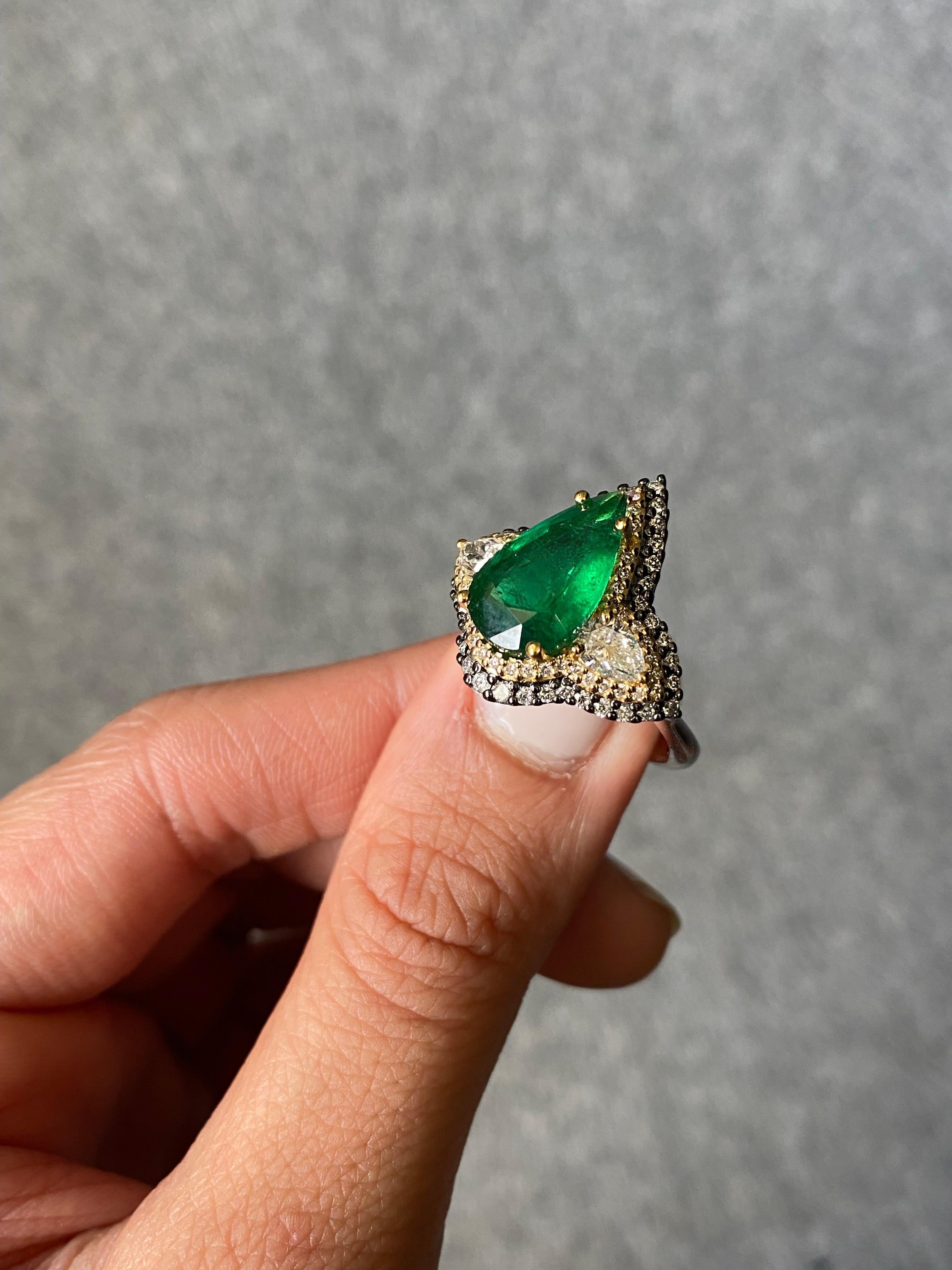 Bague de style Art déco en or bicolore 18k avec émeraude de Zambie et diamant en forme de poire à pavage français de 3,28 carats.

Ajoutez l'influence de l'ère Art déco à votre collection de bijoux fins avec cette bague unique en or 18k, réimaginée