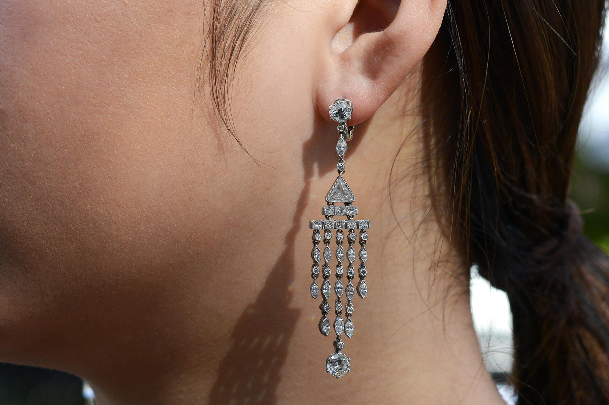 These fascinating chandelier earrings utilize a variety of different diamonds cuts, from the classy round brilliant to an intriguing trillion cut. The waterfall of twinkling diamonds feature horizontal rows of princess cuts that taper to columns of