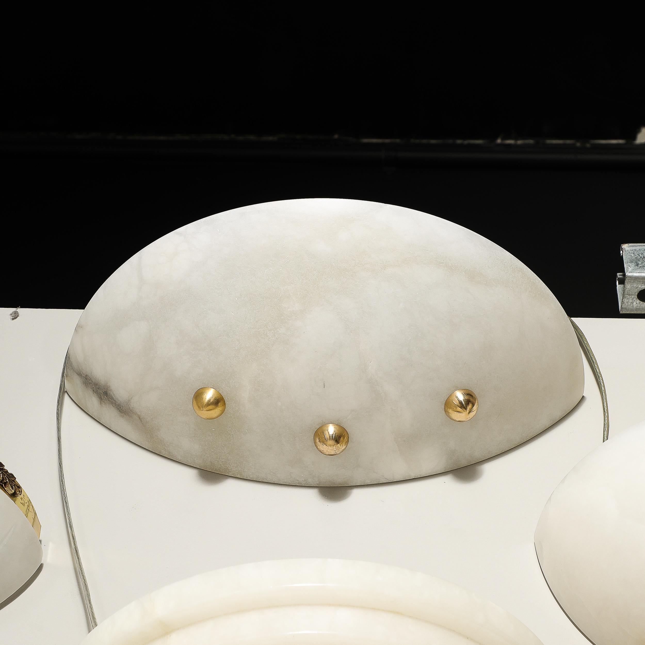 Questa elegante e minimale applique in alabastro in stile Art Déco con finiture a sfera in ottone proviene dalla Francia della seconda metà del XX secolo. Presenta un paralume allungato e curvo in alabastro intagliato con sottili venature e una
