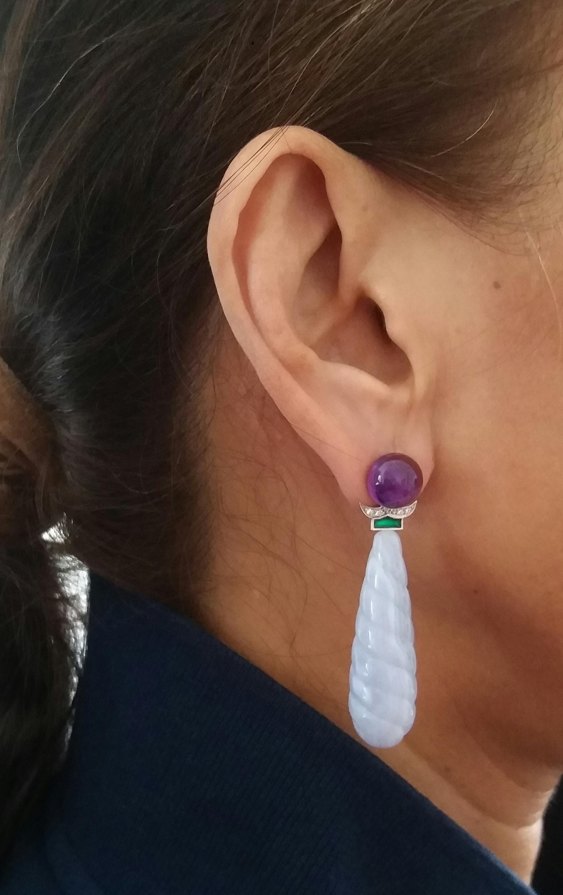 In these earrings we have the upper part consisting of 2 round buttons amethyst, at the bottom 2 engraved blue lace agate round drops measuring 12x 40 mm, surmounted by 2 elements in white gold diamonds and green enamel.
In 1978 our workshop started