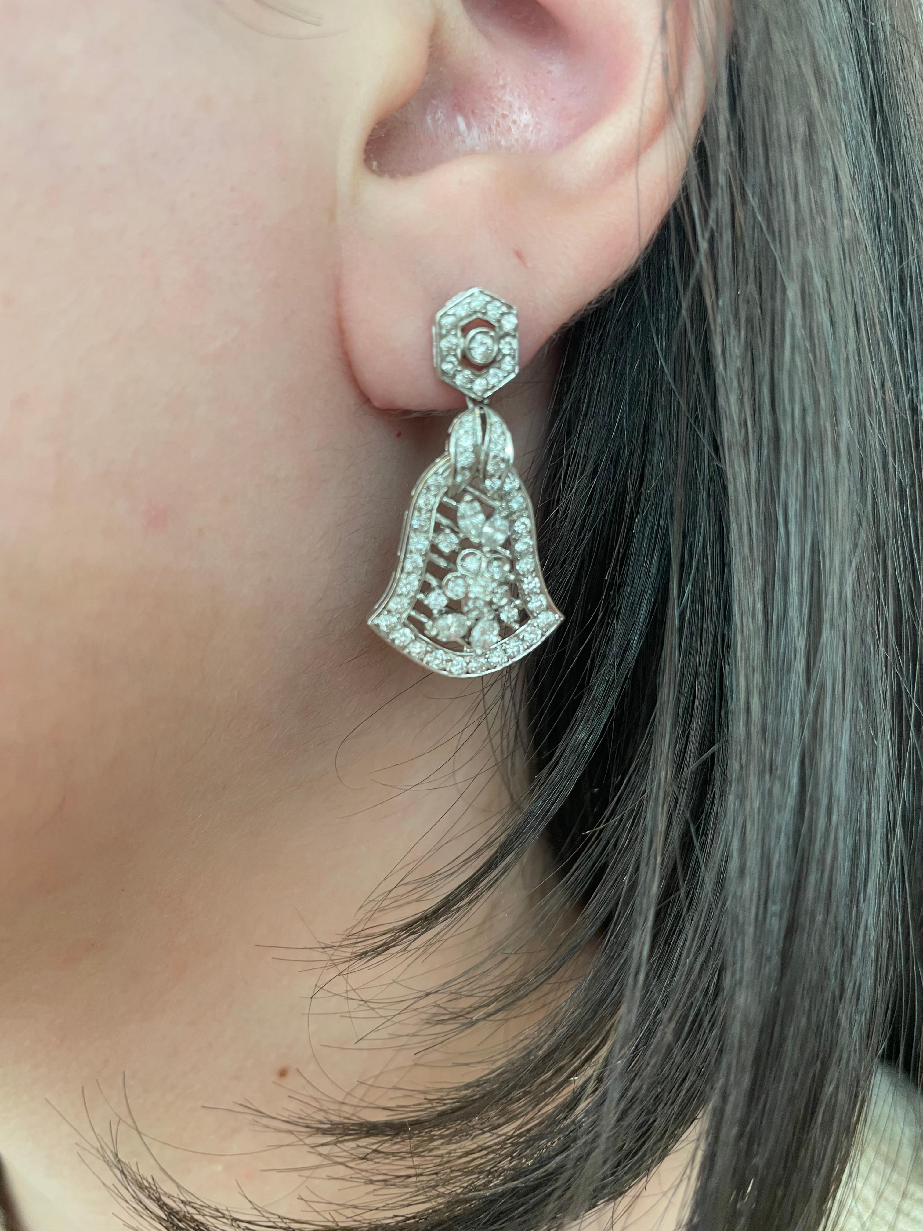 Beautiful Art Deco inspired bell motif earrings
Round cut diamonds approximately 1ct, H/I color, and SI clarity. 18-karat white gold with millgrain work. 1 inch. 
Accommodated with an up to date appraisal by a GIA G.G. upon request. Please contact