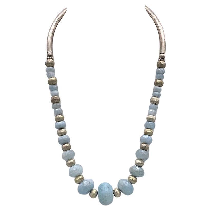 This is an Art Deco style aquamarine and sterling necklace. We created this necklace with up to 21 mm faceted frosted aquamarine rondels and 9 mm textured sterling rondel beads as spacers. It has 2.75 inch textured sterling curved tubes and a
