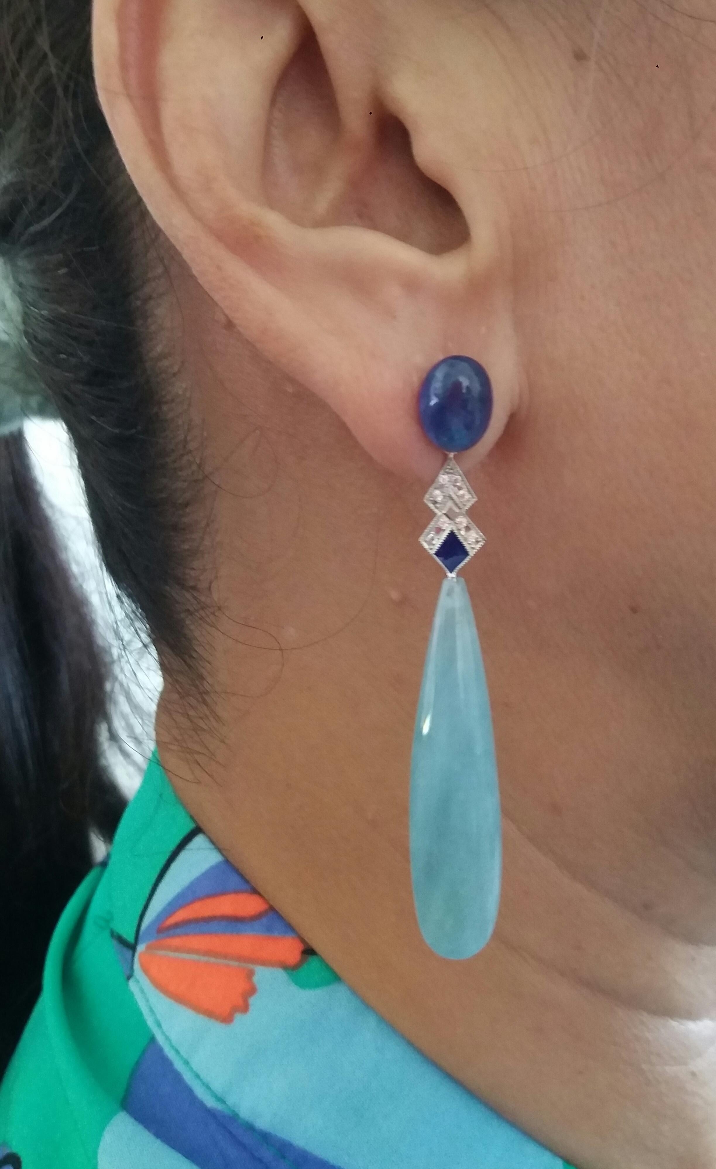 In these Classic Art Deco style earrings we have 2 very good quality Natural Thai Blue Sapphire cabochons measuring 7,5 x 10 mm. as  tops, middle parts are in white gold ,16 round full cut diamonds and blue enamel,while in the lower parts there are
