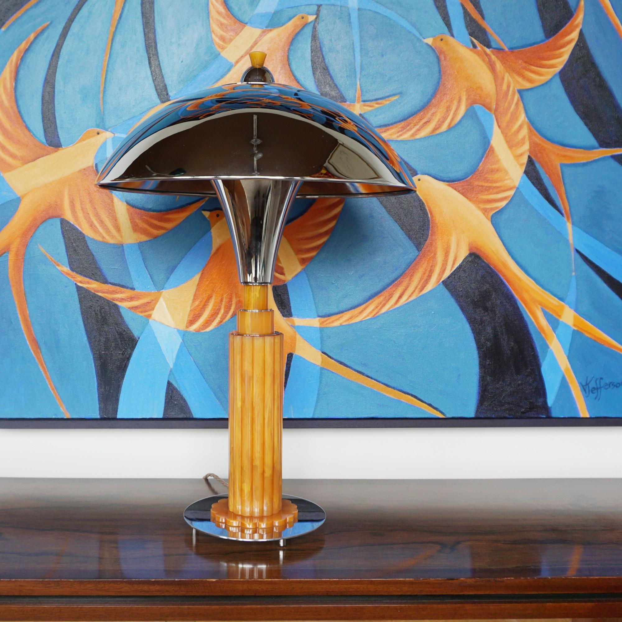 Eine Kuppellampe im Stil des Art déco. Geriffelter Stiel aus orangefarbenem Bakelit auf einem runden verchromten Metallsockel. Verchromter Metallschirm mit Bakelit-Finale an der Spitze. 

Abmessungen: H 56cm T 38cm

Herkunft: Englisch

Artikel
