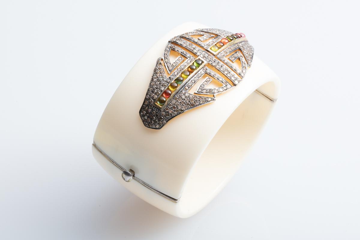 Large white bakelite hinged cuff with pave`set diamonds and cabochon tourmalines in an Art Deco style design.  Set in oxidized sterling silver with push clasp.  Inside circumference is 6 1/2 inches.  Diamond weight is 2.62 carats and the tourmalines