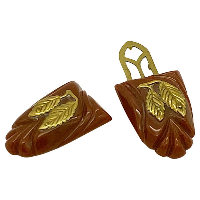 This is a pair of Art Deco style Bakelite dress clips. These brick red color carved Bakelite dress clips are decorated with two brass leaves each. They could be worn as brooches, turned into pendants or could be clipped on a collar or jacket top