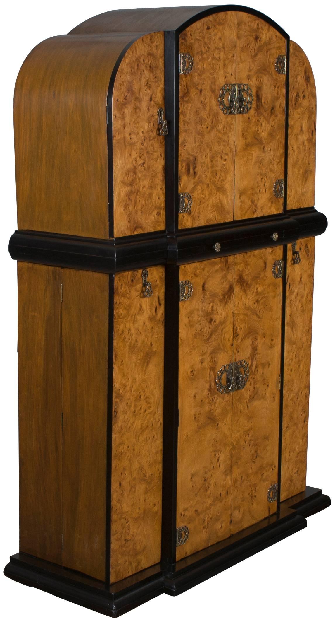 This is a very unique and beautiful Art Deco style bar that was made in England around the year 1940. The bird's-eye maple veneers are accented with painted black moldings that really define the Art Deco style. With six cabinet areas for storage,