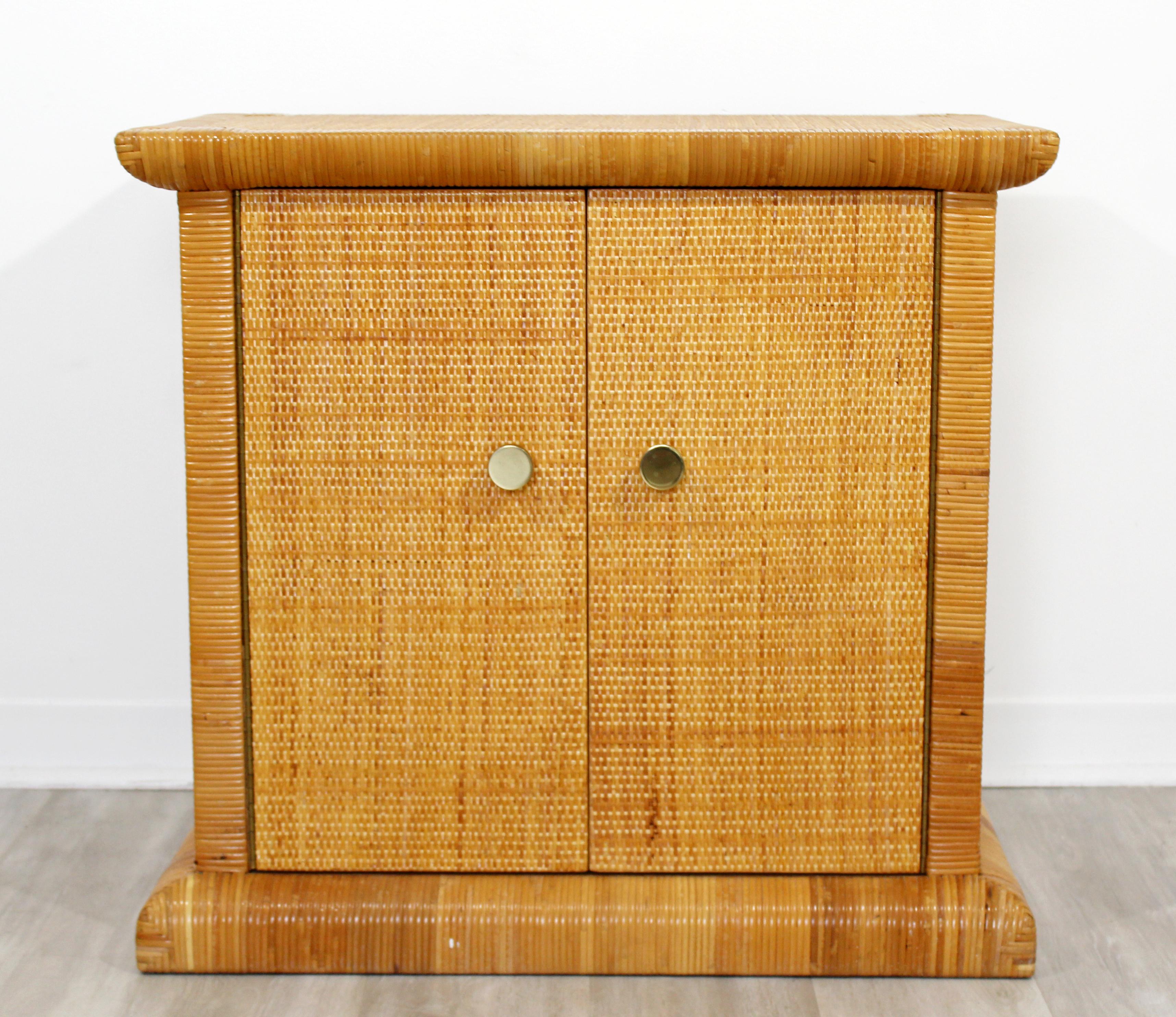 For your consideration is a charming, cane rattan and brass side cabinet, with two doors and one shelf, by Bielecky Brothers, made in the U.S. circa 1990s. In very good condition. The dimensions are 30